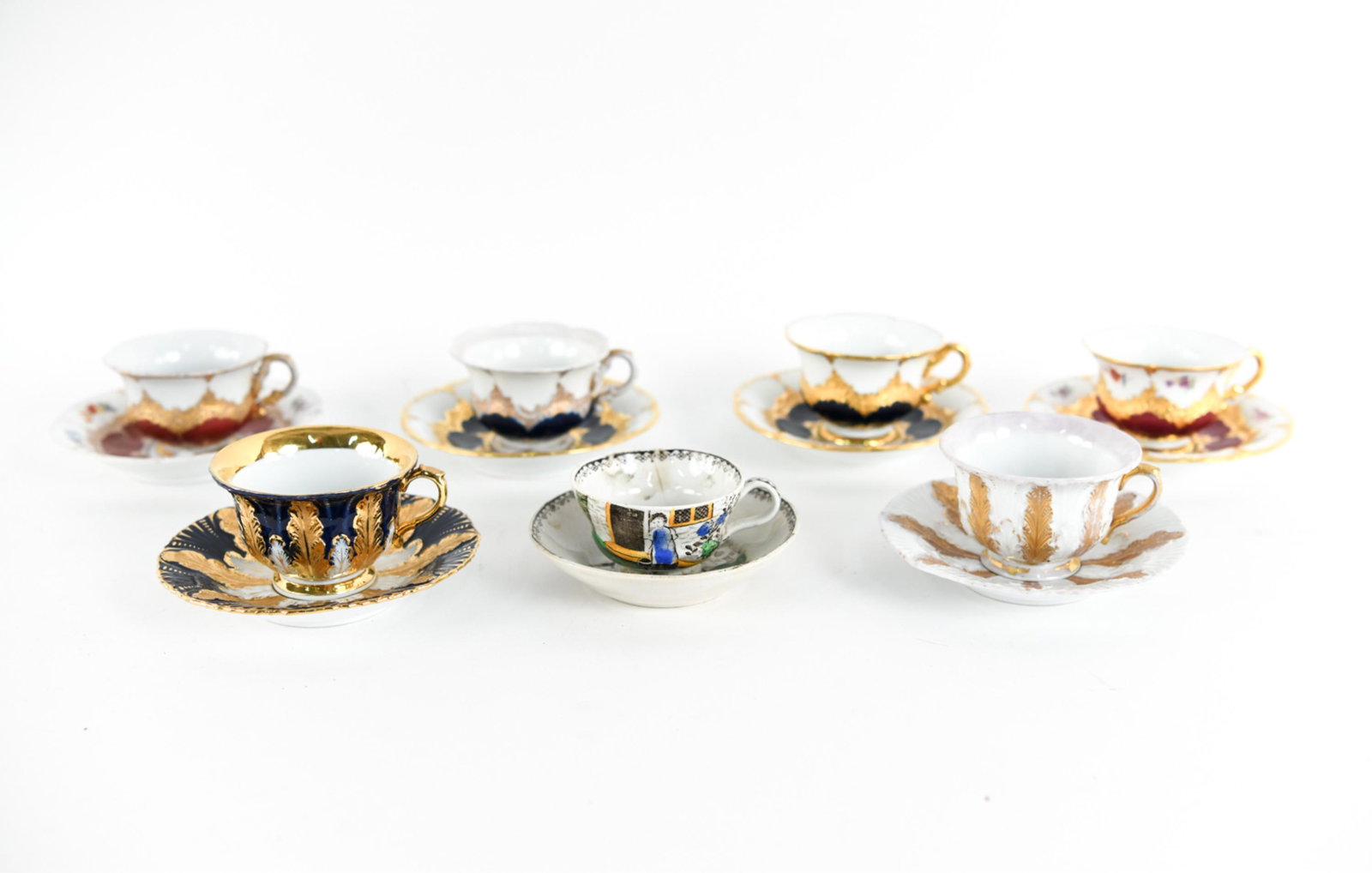 PORCELAIN DEMI-TASSE & SAUCER GROUPING: Including one wooden display stand, marked with crossed swords, possibly Meissen. Dimensions: (Largest saucer) Dia. 5" Condition: Some rubbing to surfaces, scattered chips.