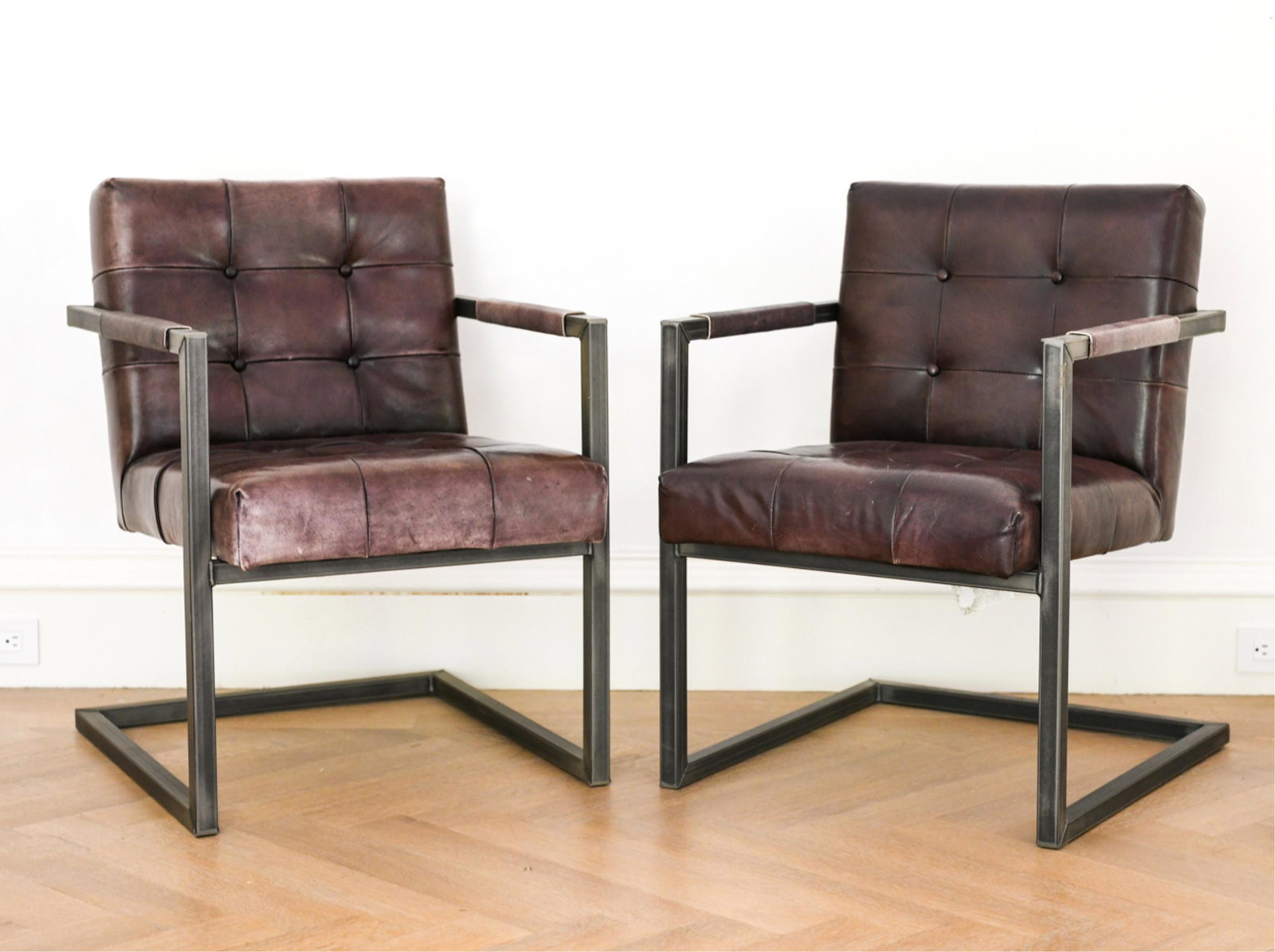 PAIR OF TUFTED LEATHER CANTILEVER ARMCHAIRS: Contemporary. Brown leather. Dimensions: H 33" x W 24" x D 27" x SH 18.5" Condition: Some fading, scratches, spots, and scuffs to leather. Showing signs of use.