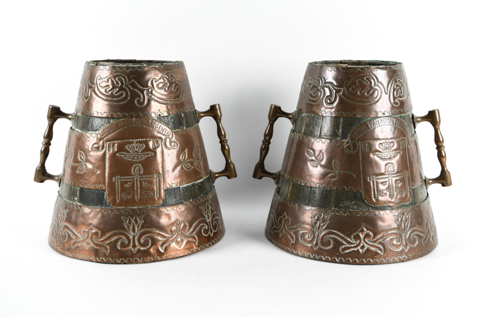 (2) KING HENRY IV COAT OF ARMS ARMORIAL BUCKETS: Arts and crafts hammered and punched copper over wood. King Henry IV copperware with armorial crest coat of arms. Dimensions: H 13" x Dia. 11" Condition: Some losses to wood. Signs of age and use.