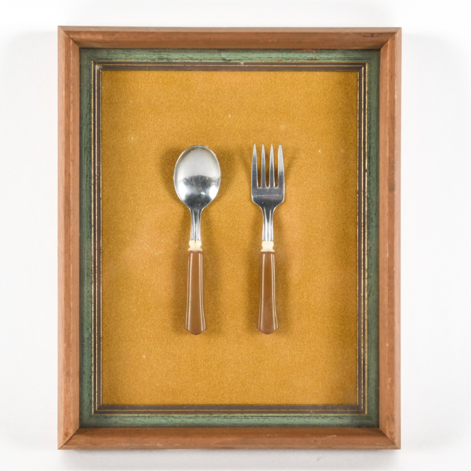 VINTAGE CHILD'S FORK AND SPOON: In shadow box frame. Dimensions: H 11" x W 9" x D 1.5" Condition: Wear from age including minor nicks and scuffs to frame.