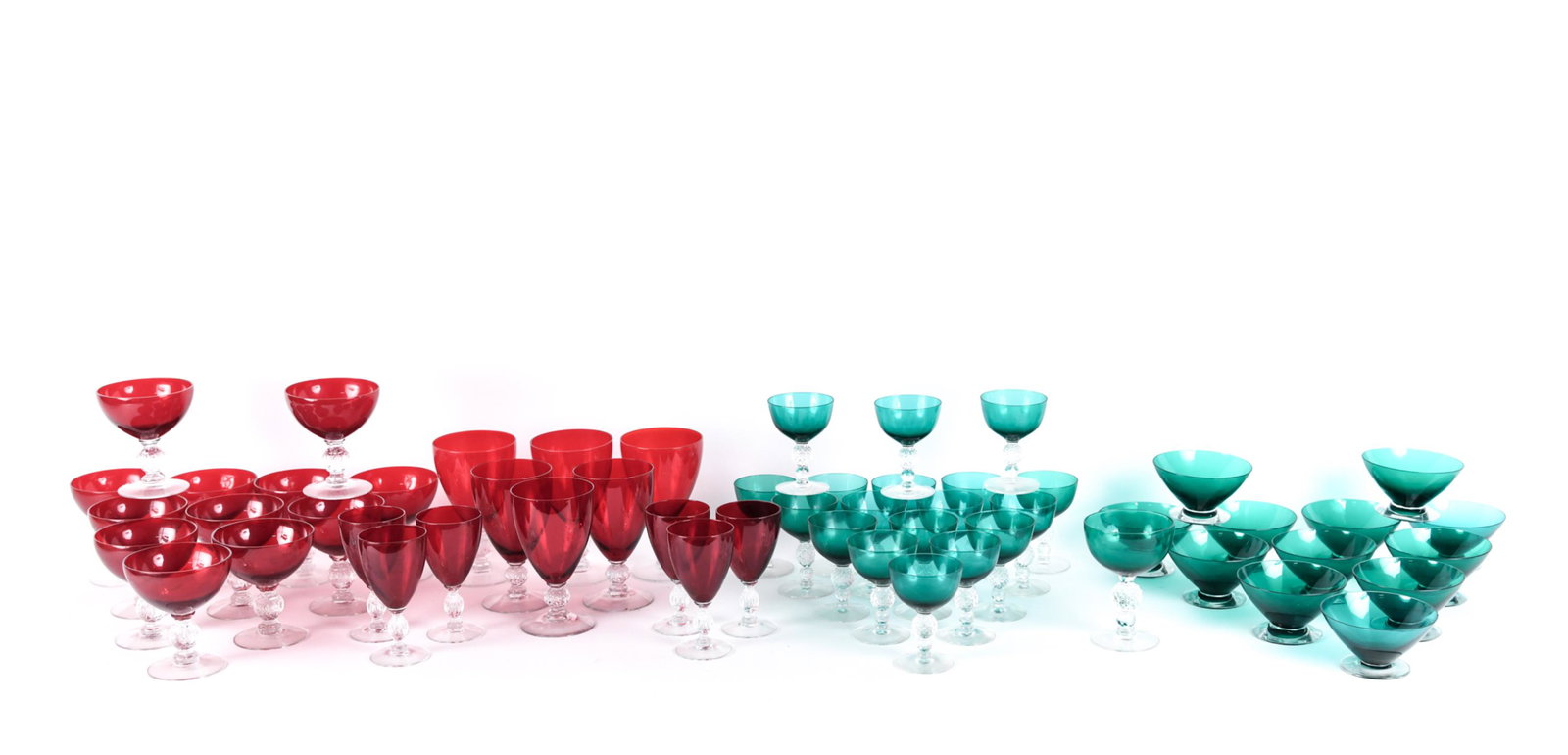 GROUPING OF RED & GREEN GLASSES STEMWARE: Unmarked. Colored glass tops with pressed glass bases. Including (12) red sorbet glasses, (5) red small wine goblets, (6) red water glasses, (18) green cordial glasses, (1) green goblet, (12) green de