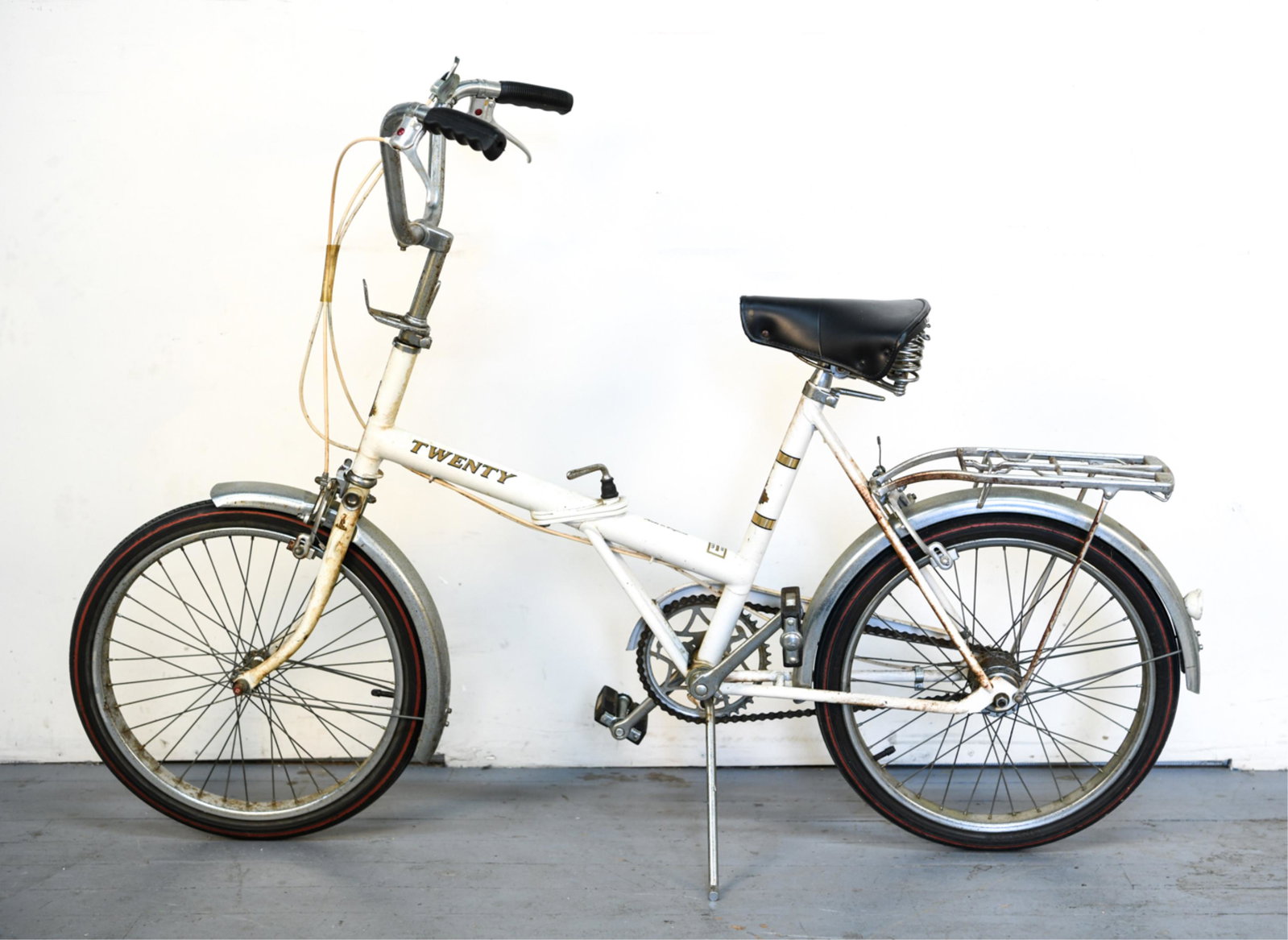 RALEIGH 20 TRAVELING BICYCLE: Folds in half. Marked The Raleigh, Nottingham England on back. Marked in center made in England. Dimensions: H 41" x W 59" x D 22" Condition: Spots of rust throughout.