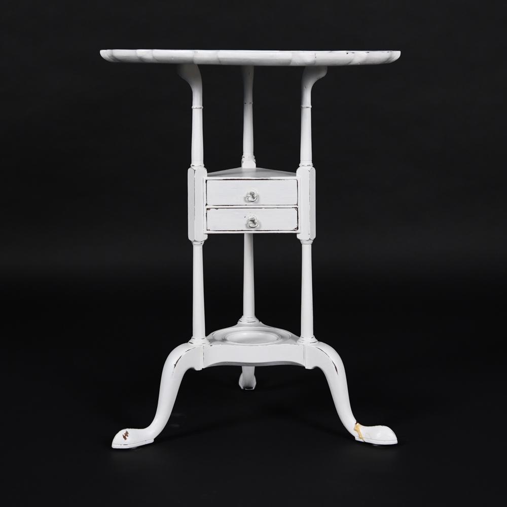 SCALLOPED EDGE SIDE TABLE IN WHITE PAINT: Including (2) small drawers. Dimensions: H 27.5" x Dia. 21" Condition: Wear consistent with age and use including scuffs, paint loss and surface scratches. Previous break with glue repair on (1) foot.