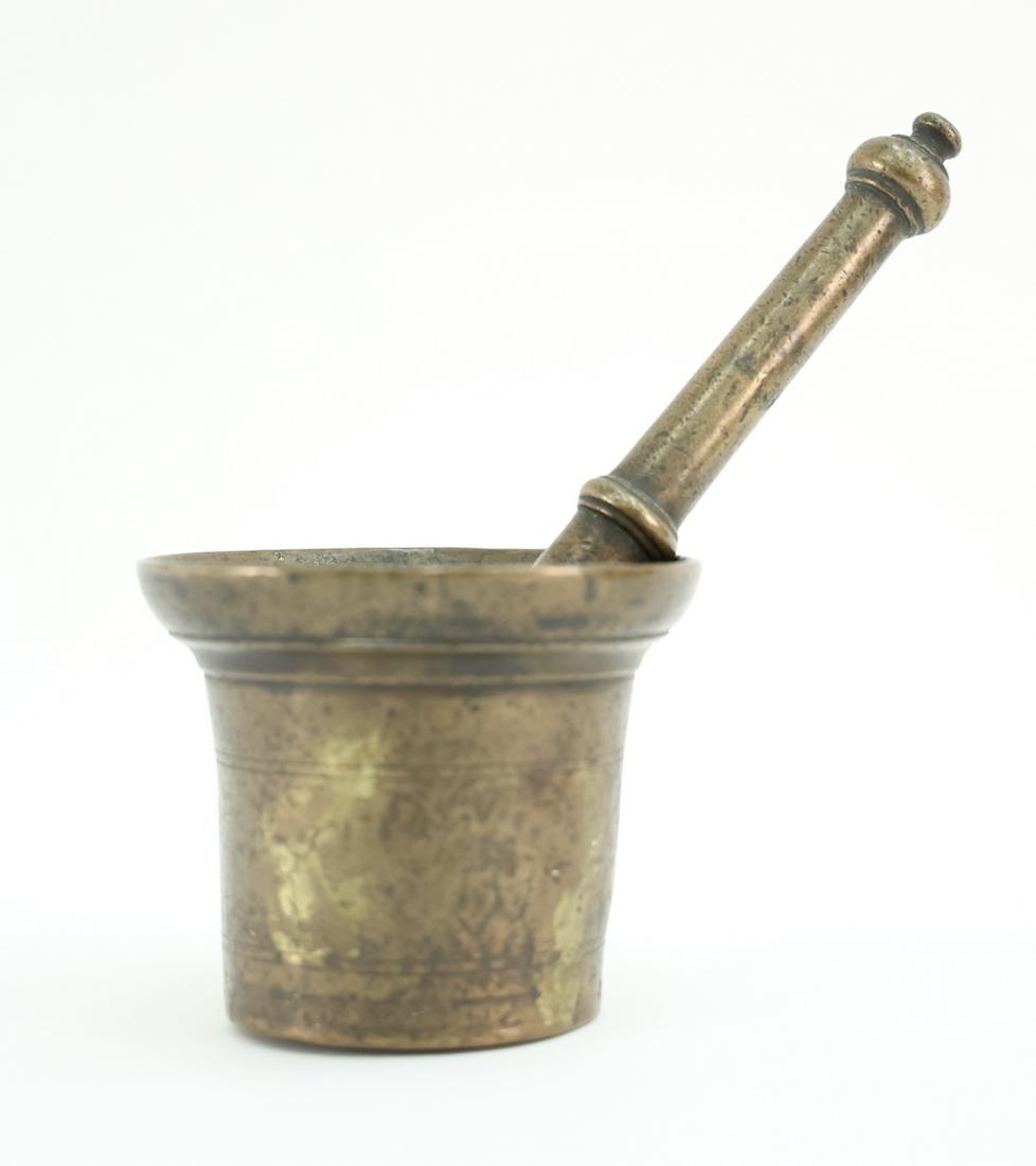 BRASS MORTAR AND PESTLE: Apparently unmarked. Dimensions: H 10" x W 2" Condition: Showing signs of use including some dents and dings to metal. Small crack to side of mortar.