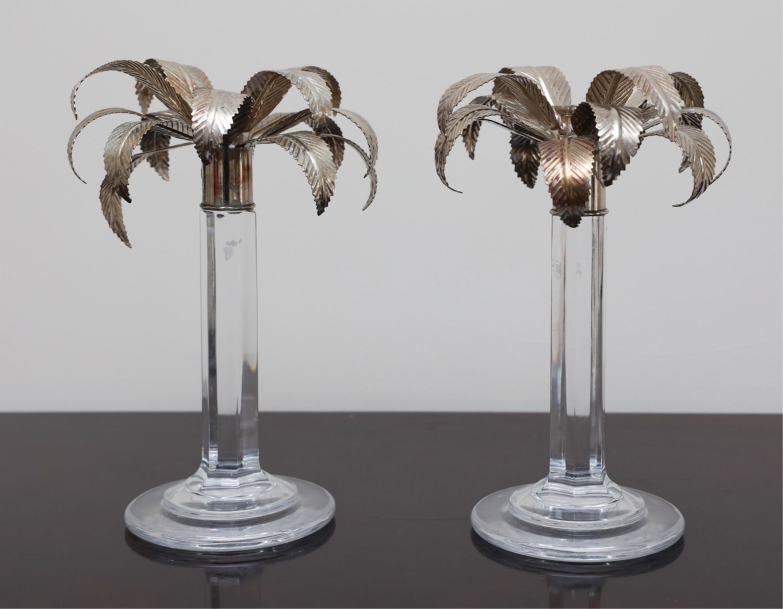 PAIR OF WILLIAM YEOWARD CRYSTAL PALM CANDLESTICKS: Signed underneath crystal bases: William Yeoward. Dimensions: H 11" x Dia. 7.5" Condition: One missing bobeche insert. Signs of use including some wax. Note: We are offering in-house shipping to the C