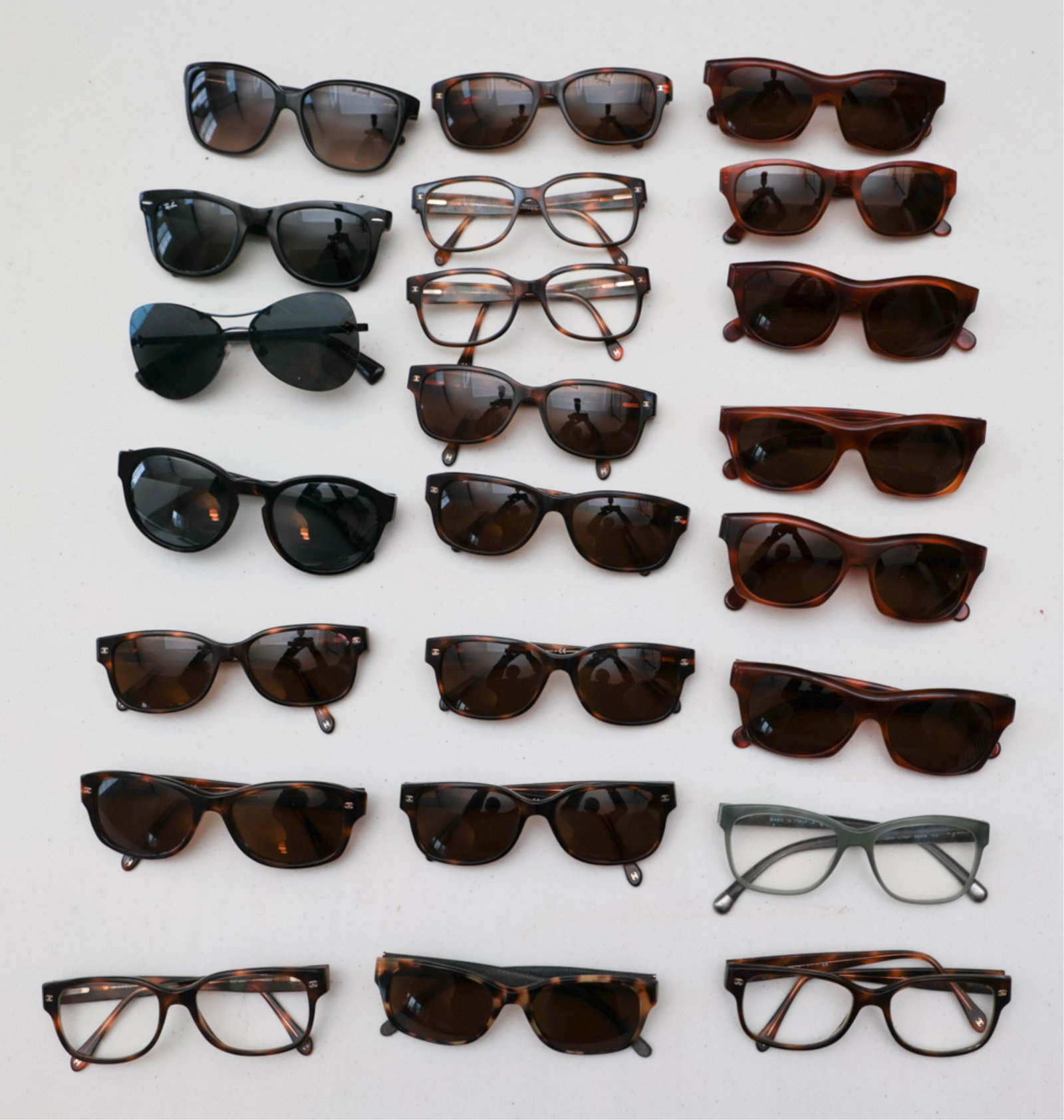 GROUPING OF DESIGNER SUNGLASSES INCL. CHANEL: Including Chanel, Raybans, Gucci, Ferre, etc. Dimensions: (Largest) H 2" x W 5.5" x D 6" Condition: All prescription. Used, some signs of use. Note: We are offering in-house shipping to the Continenta