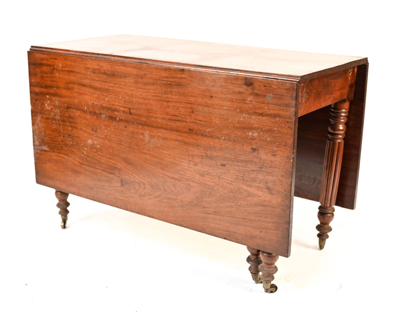 ANTIQUE DROP LEAF TABLE: drop leaf table on casters. Dimensions: H 28.5" x W 44" x D 21" (Leaf) W 21" Condition: Watermarks, scratches, and dings to table throughout.