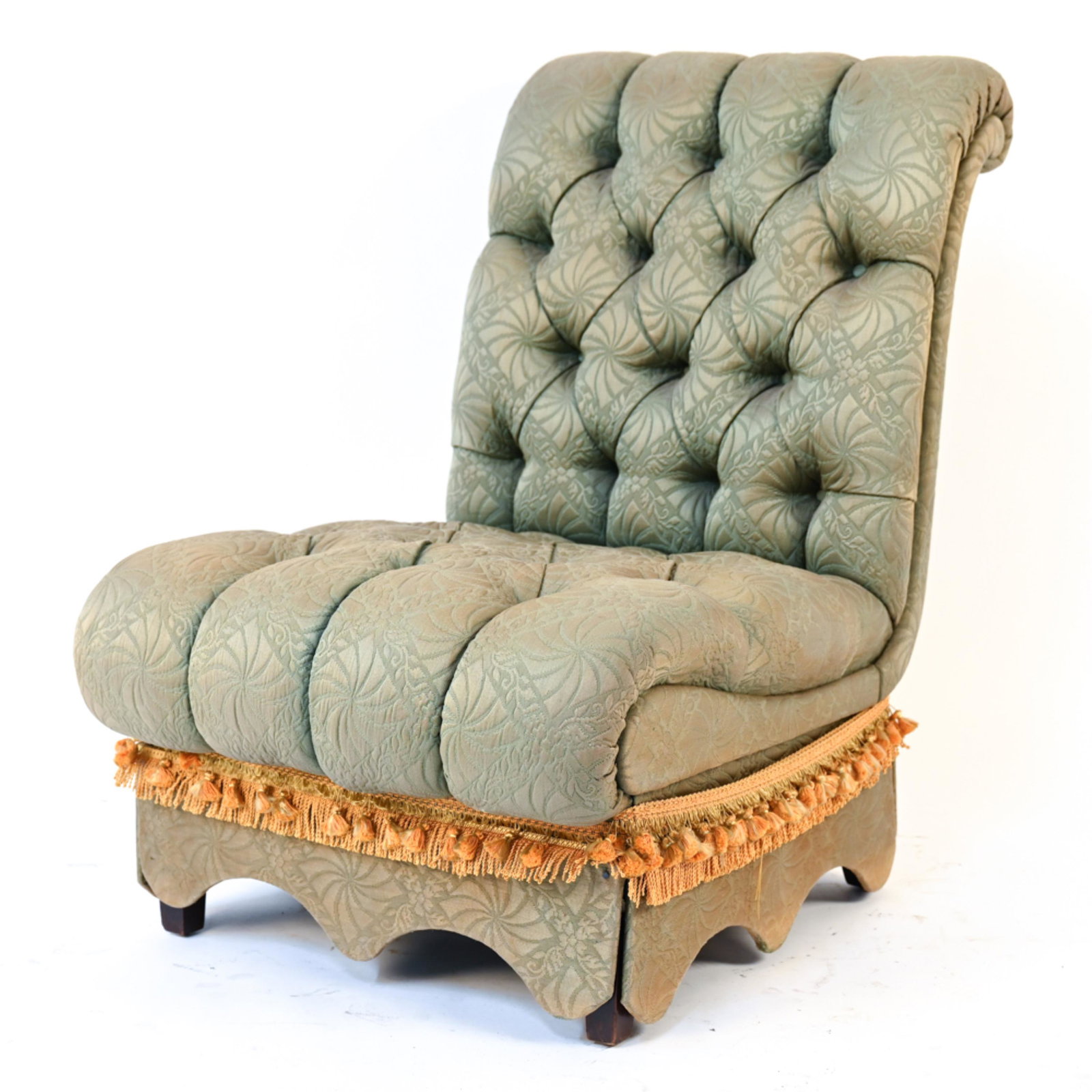 TUFTED SLIPPER CHAIR: Green upholstered slipper chair with tassels. Dimensions: H 35" x W 24" x D 34" SH 16" Condition: Light staining and pulls to upholstery. Legs with nicks and scratches. could use reupholstery