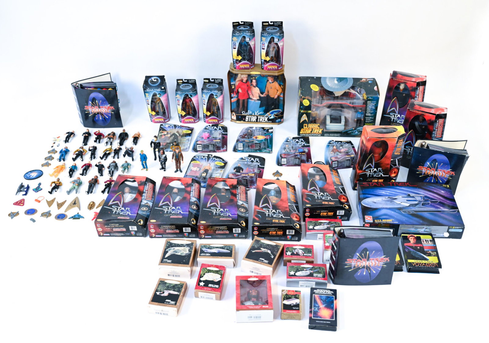 STAR TREK FIGURE & COLLECTIBLES COLLECTION: Grouping of Star Trek action figures, ornaments, videos, and books. Dimensions: H 11" x W 17" x D 9" Condition: Boxes opened with dents. Showing signs of use.