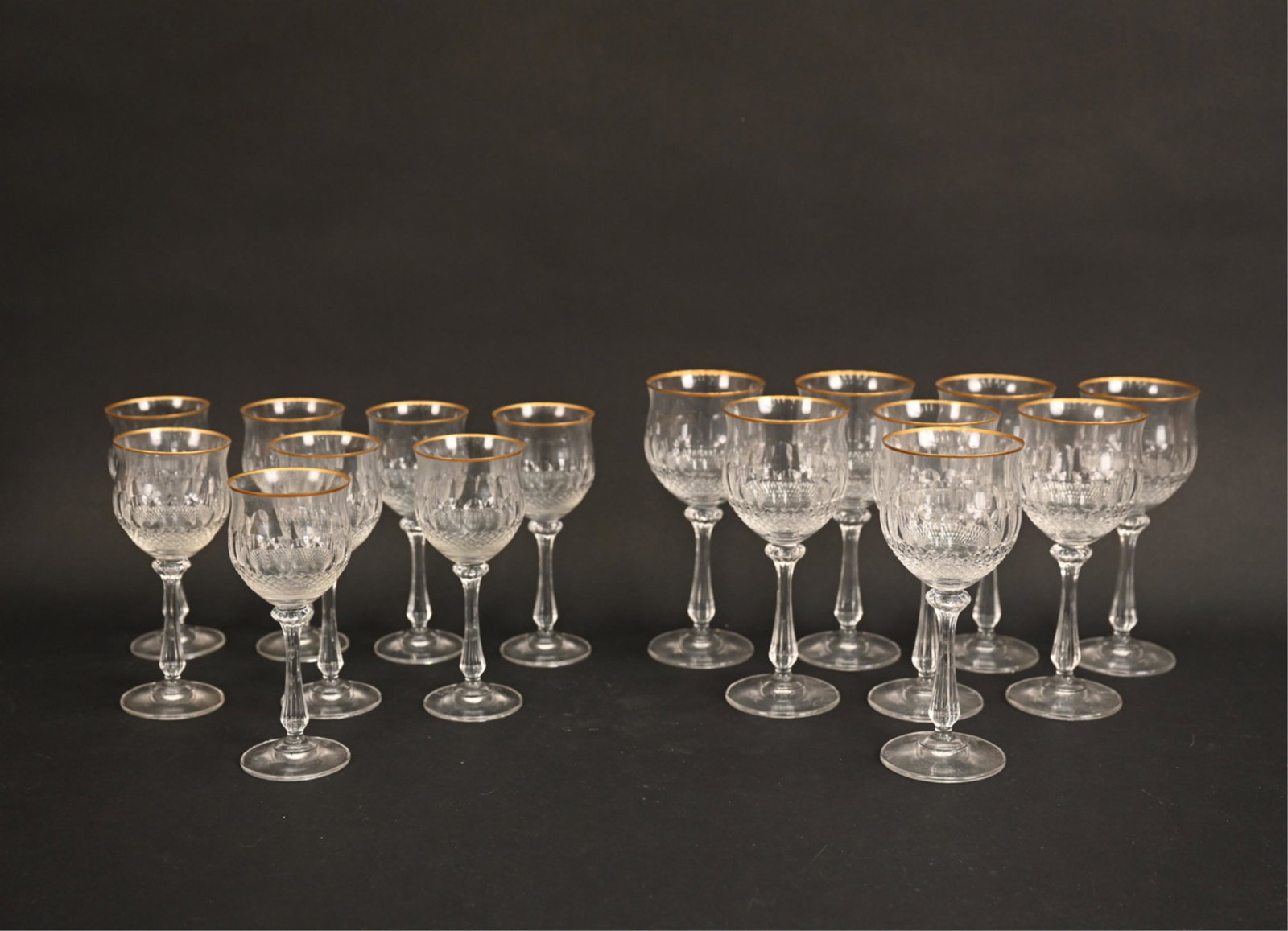 GOLD RIM CRYSTAL WINE GLASSES: (8) red wine and (8) white wine cut crystal goblets with gold rim. Unmarked. Dimensions: (Larger) H 8" x Dia. 3.5" Condition: Few minor scratches, very light wear.