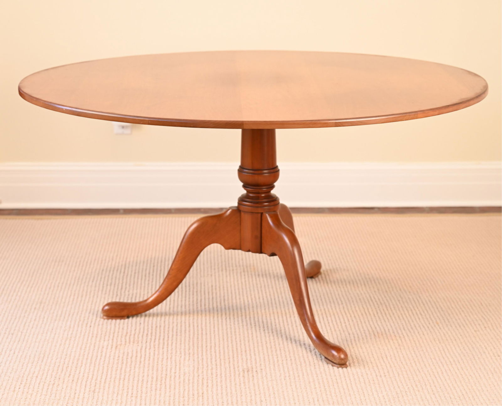 ELDRED WHEELER CHERRY PEDESTAL TABLE: New England Queen Anne style. Stamped underneath. Tilt top. Seats six.Dimensions: H 29.75" x Dia. 53.75"Condition: Light use wear. Rubbing on the edges and feet.
