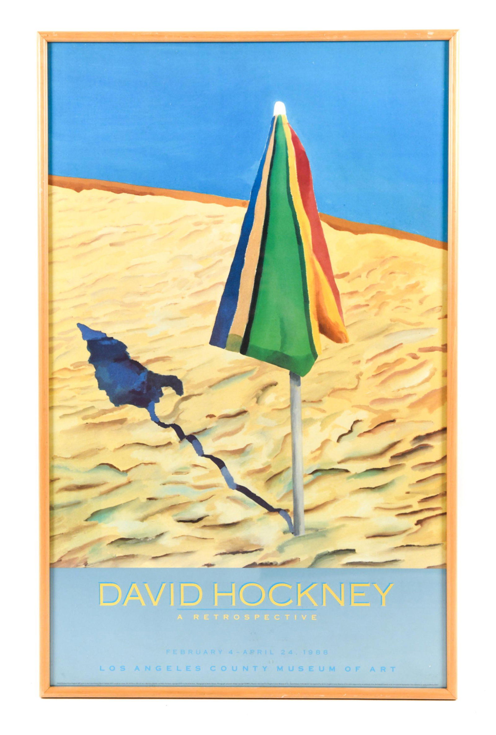 DAVID HOCKNEY 1988 LACMA EXHIBITION POSTER: Poster for 1988 David Hockney retrospective exhibition at Los Angeles County Museum of Art featuring the 1971 painting "Beach Umbrella". Dimensions: (Frame) H 40" x W 25" Condition: Minor rubbing and 