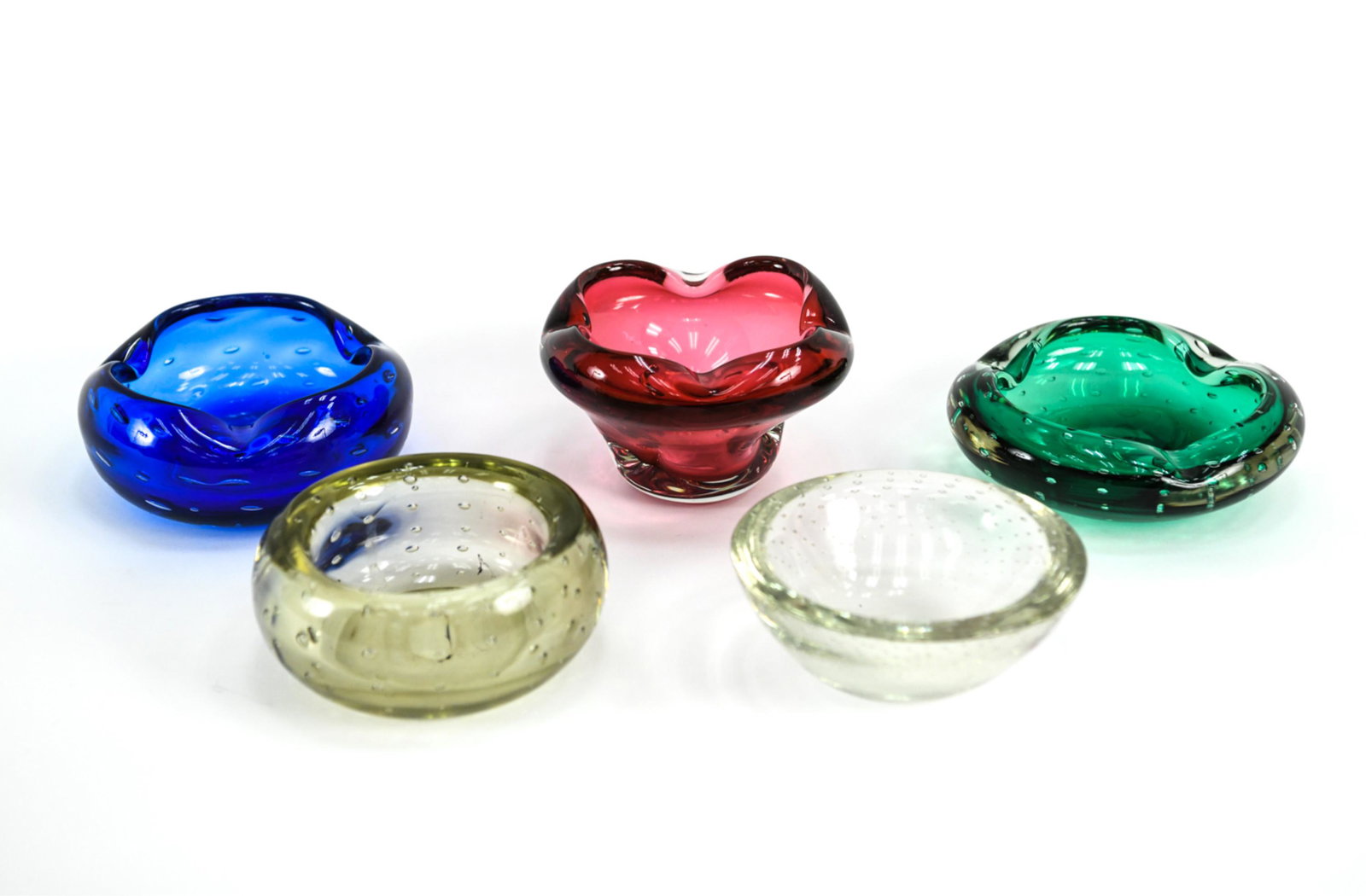 (5) MID-CENTURY BOWLS, INCL. BLENKO BUBBLE GLASS: Grouping of (5) bowls, including: Blenko 508 "Bubble Ashtray" in Turquoise; emerald green ashtray, possibly Erickson Glass or Blenko; amethyst/rose glass ruffled quatrefoil bowl; and (2) bullicante cr