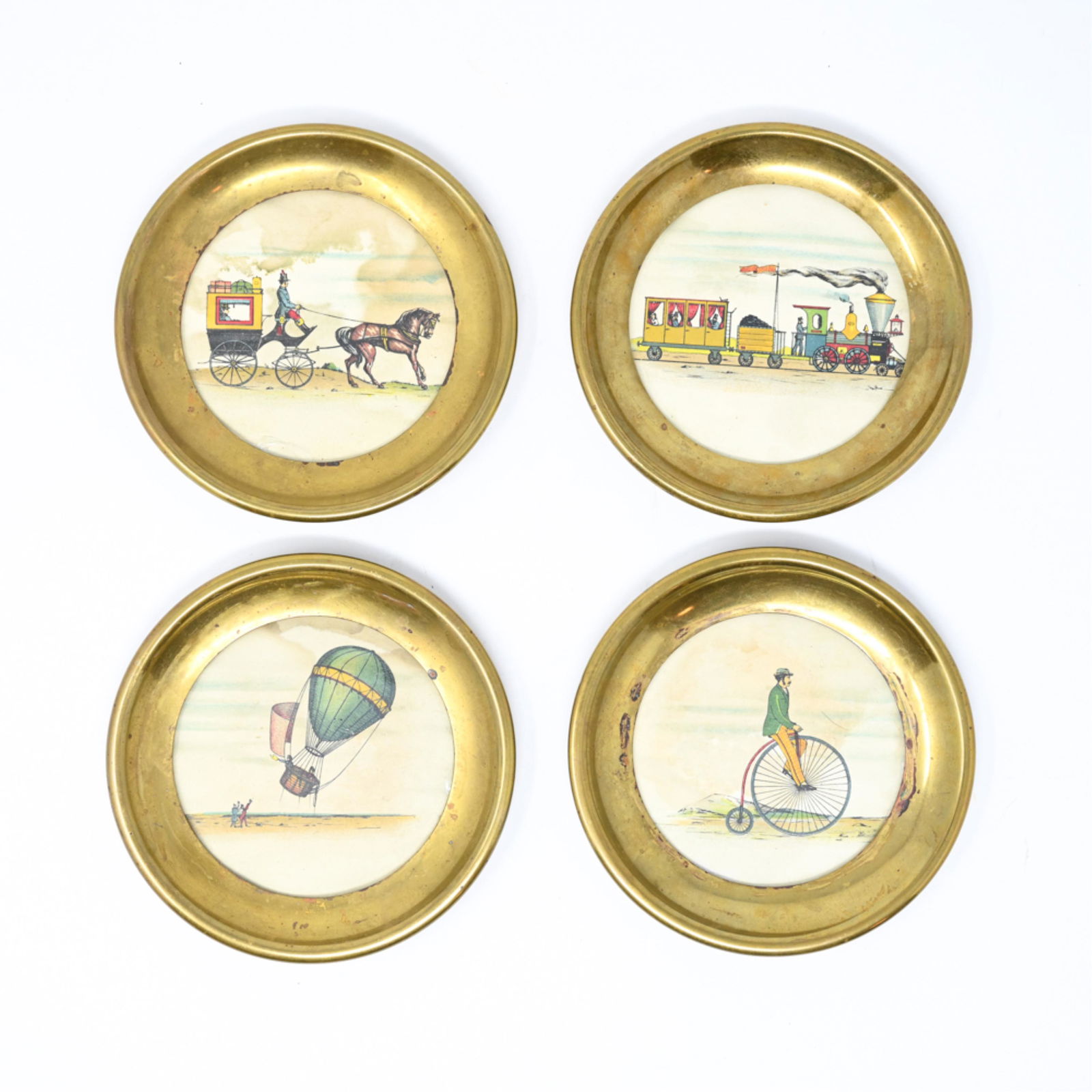 (4) ITALIAN COASTERS IN MANNER OF FORNASETTI: Marked underneath: Made in Italy. Hand colored engravings in brass fittings. Dimensions: Dia. 4.5" Condition: One with cracked glass. Some water staining. Tarnish to brass.