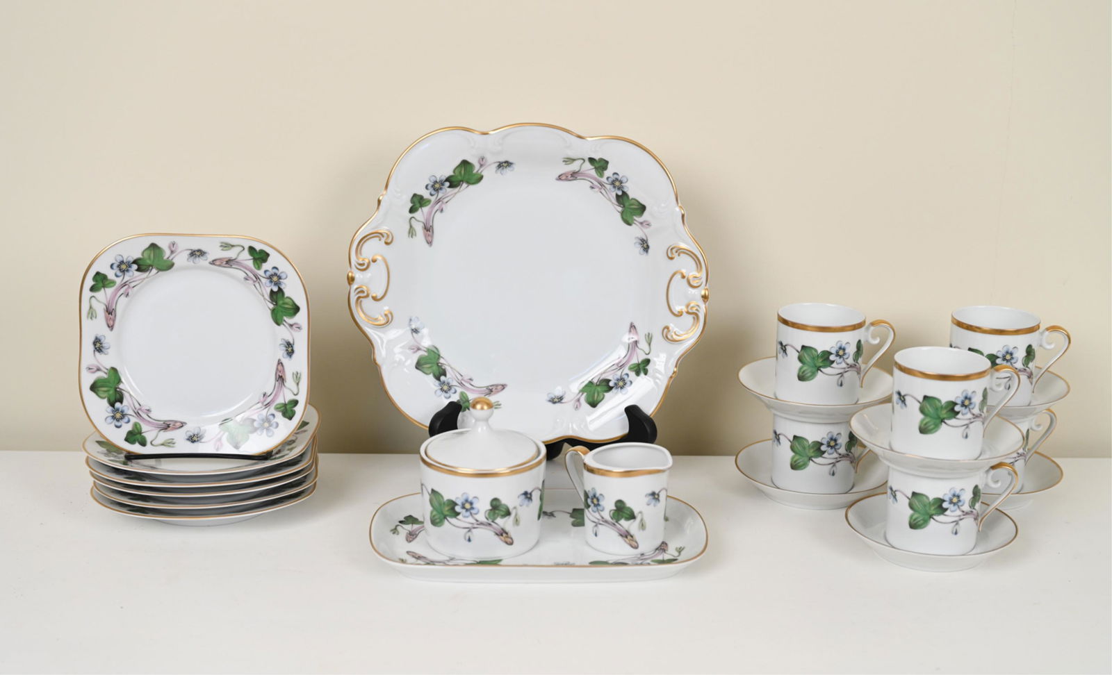 HACKEFORS SWEDEN PORCELAIN TEA SERVICE: "Anemone Hepatica." Marked underneath: Hackefors Porslin, Sweden. Including round serving plate, small rectangular tray, creamer, sugar, (6) demi-tasse cups, (6) saucers, and (6) square plates. Dimens