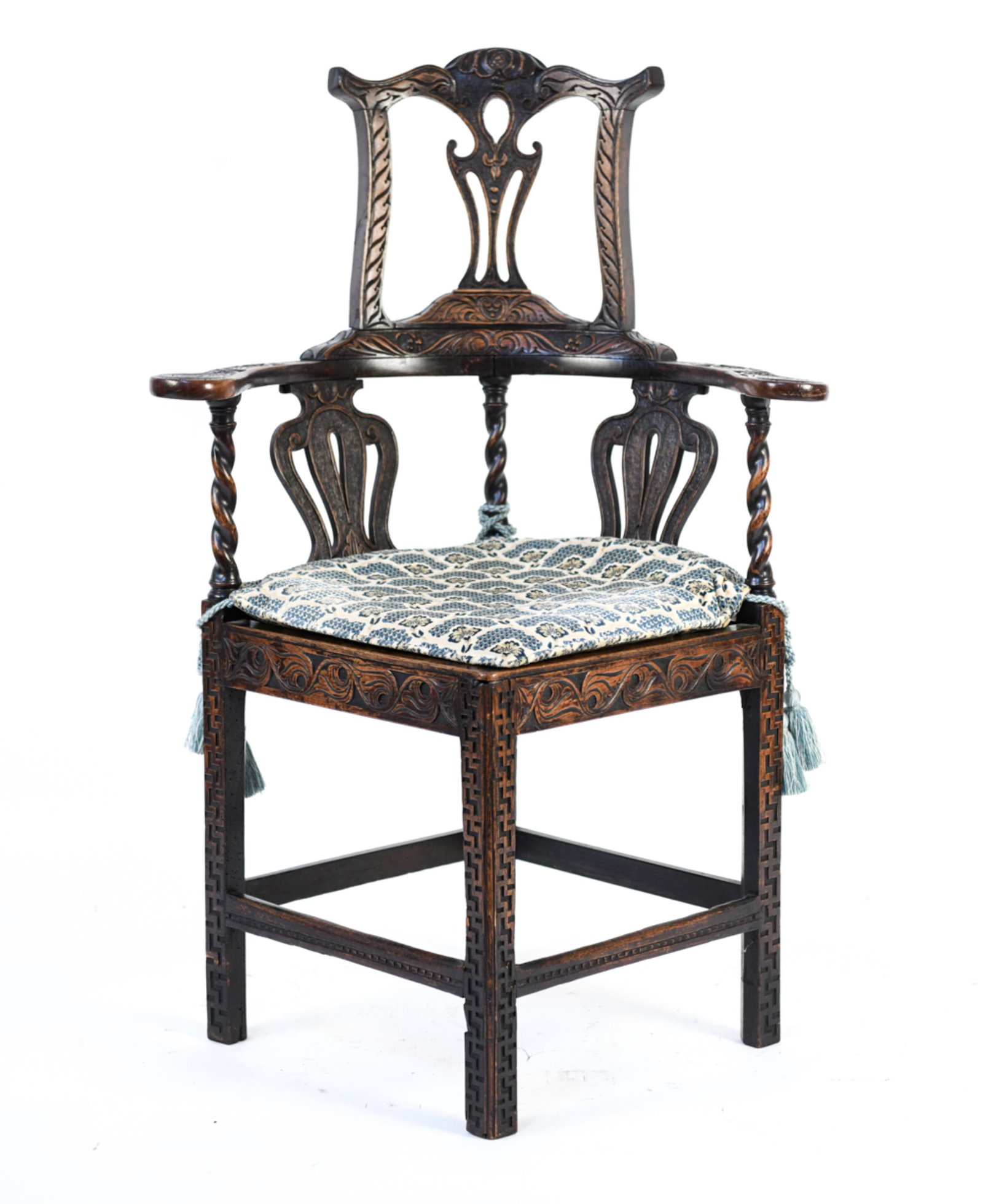 ANTIQUE HEAVILY CARVED HIGH-BACK CORNER CHAIR: With pierced splat back and crown, scrolled flat arms, interesting twist-turned stile and arm supports, and geometric carved legs. Hand-wrought iron nails join the crown to the back. With cisele broca