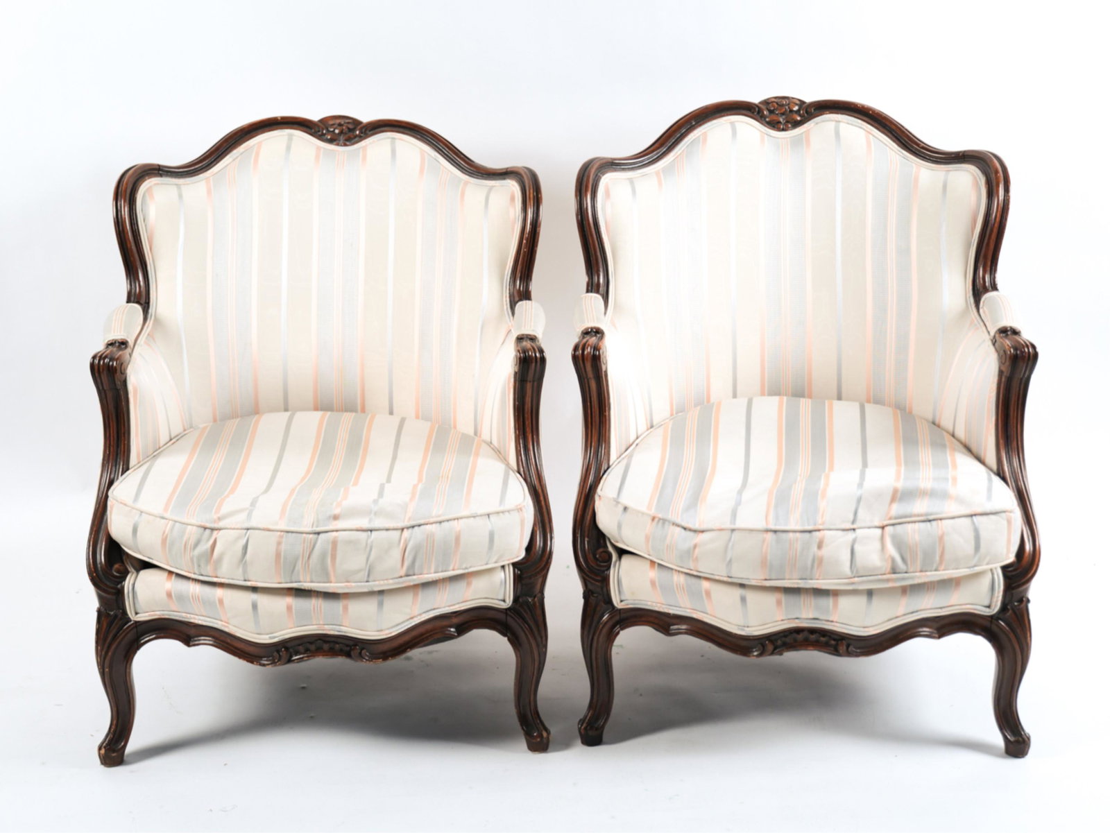 PAIR OF FRENCH LOUIS XV STYLE BERGERE CHAIRS: In striped upholstery. Dimensions: H 32.5" x W 25.75" x D 22" x SH 15" Condition: Some spots of soiling to upholstery. Some rubs and nicks to wood. Some slight joint separations.