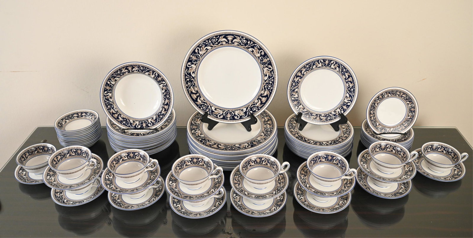 WEDGWOOD FLORENTINE BONE CHINA SERVICE FOR 12: Including (12) small bowls/compotes, dessert/bread plates, soup, salad, and dinner plates and (14) coffee cups/saucers. Marked underneath. Dimensions: (Dinner plate) Dia. 10.5" Condition: Lightly used