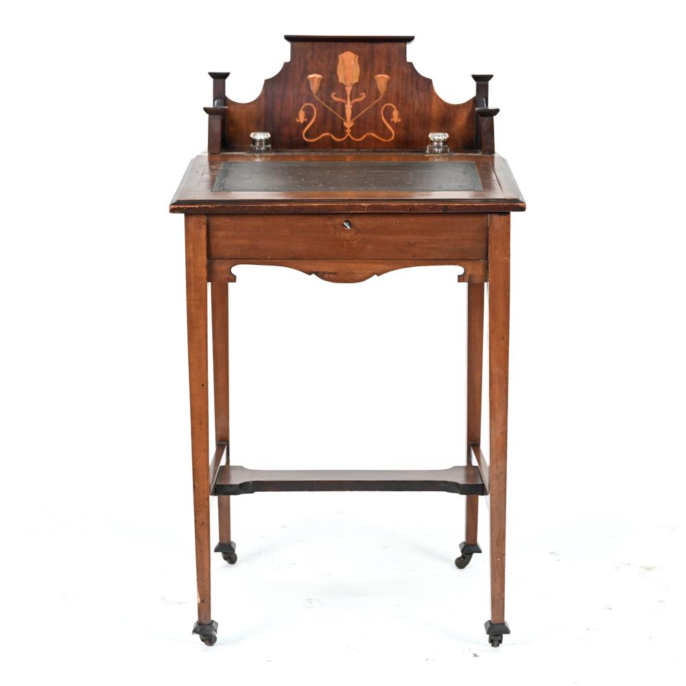 ANTIQUE INLAID LEATHER TOP DESK: With floral motif inlay, embossed leather top, including key, on casters. Dimensions: H 36" x W 21" x D 18.5" Condition: Appears to be missing part from top back. Split to top. Antique wear throughout
