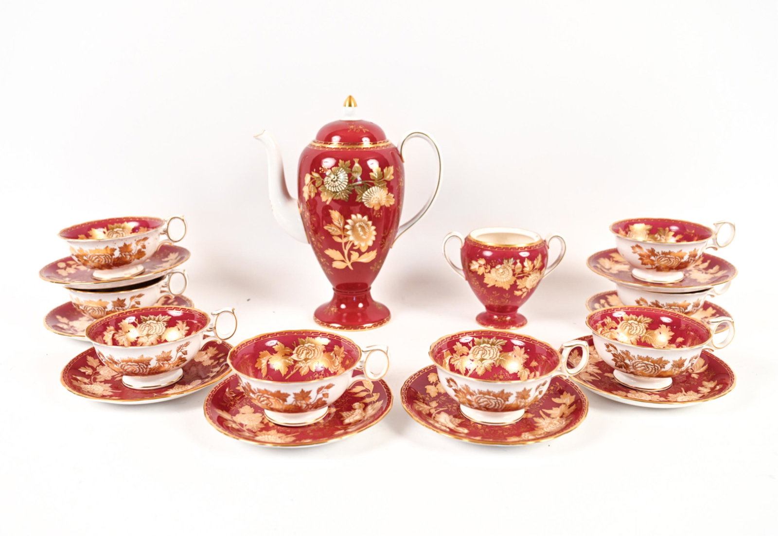 WEDGWOOD BONE CHINA COFFEE SERVICE: Marked underneath. (8) coffee cups, (8) saucers, sugar, coffee pot. Dimensions: (Coffee pot) H 10.5" x W 8" x D 5" Condition: Sugar lacking lid. Some rubs to gold. Hairlines underneath one saucer.