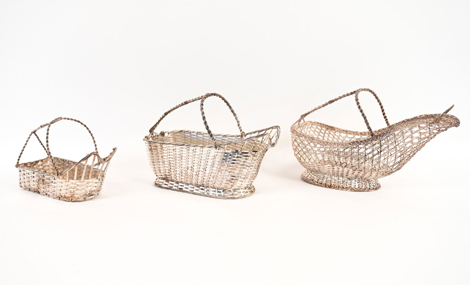 (3) FRENCH WOVEN SILVERPLATE WINE BASKETS: One marked Christofle Gallia France, both others marked "Made in France." Dimensions: (Largest) H 7" x W 11" x D 4.5" Condition: Some tarnish, minor signs of use.
