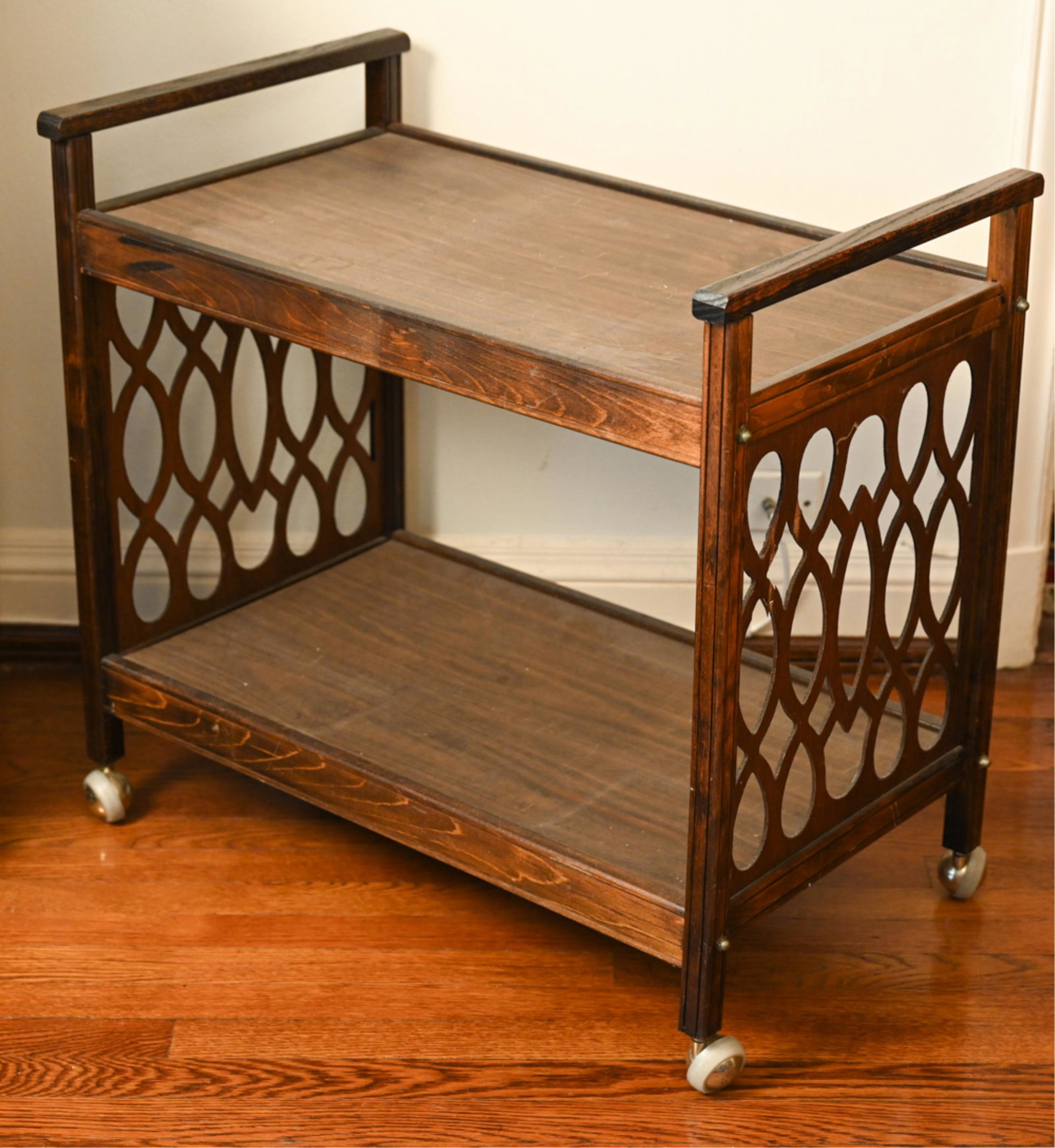 WOODEN BAR CART: Apparently unmarked, on ball casters. Dimensions: H 27" x W 29.25" x D 17.5" Condition: Slightly wobbly, some losses to veneer on side panels.