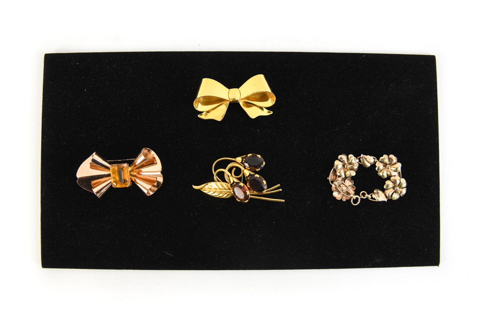 MID-CENTURY GOLD TONE STERLING SILVER JEWELRY: A sterling silver, rose gold tone bowl pin with yellow glass stone, A Coro yellow gold tone, serling silver bow pin, A Coro sterling silver, gold tone and purple stone flower pin, a gold filled, Deco