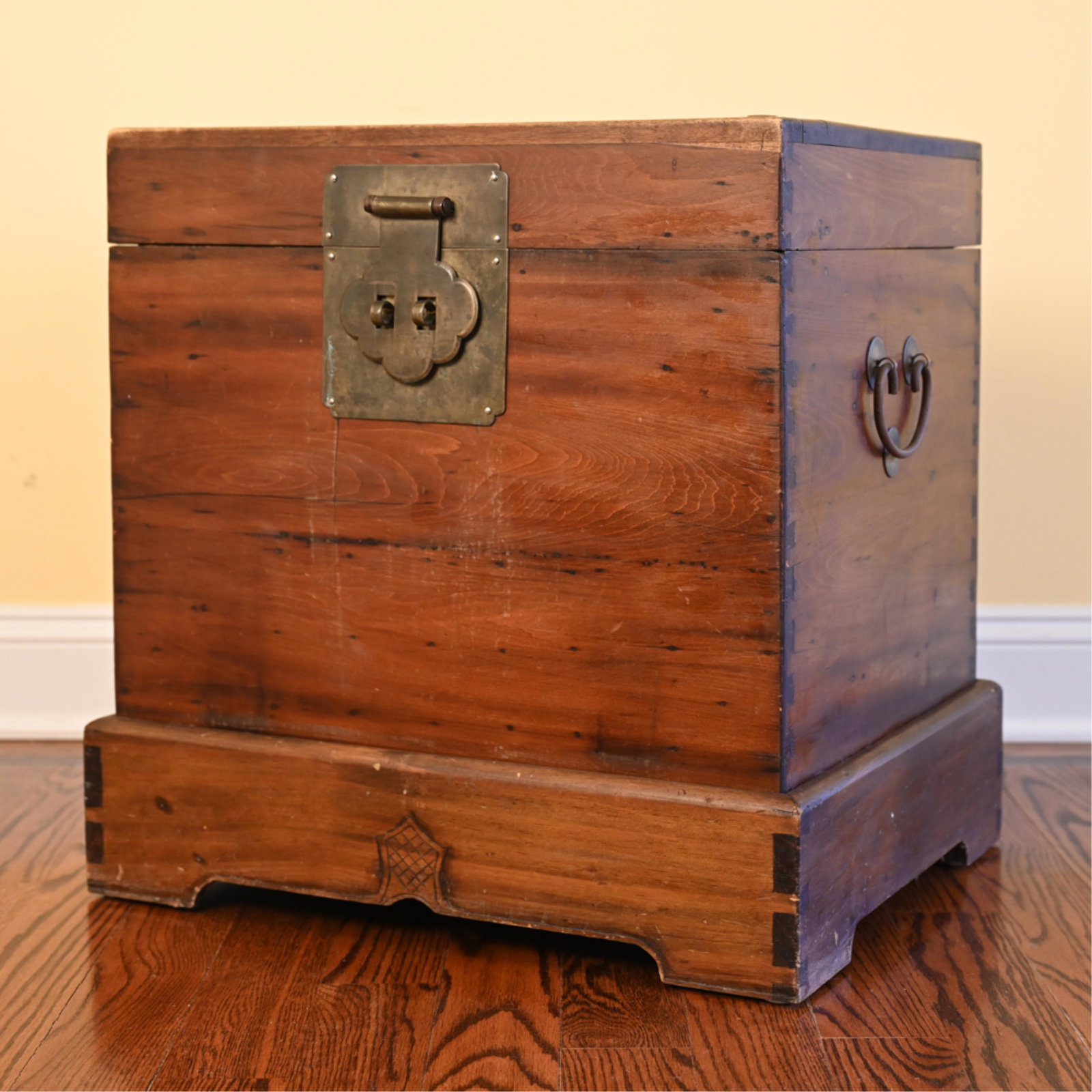 ASIAN CHEST: Chinese wooden chest on base with brass handles and lock. Chinese wax mark on top of chest. Dimensions: H 23" x W 21.5" x D 17.5" Condition: Missing locking pin. Exterior of chest with staining and sc