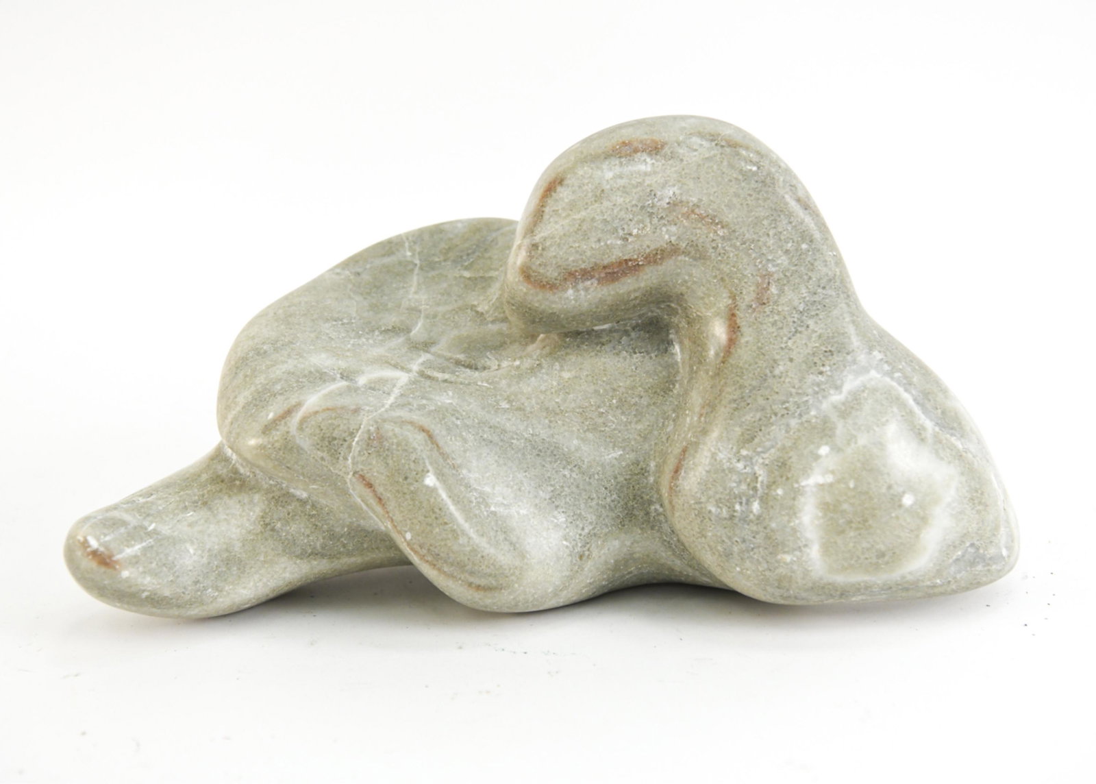 ABSTRACT CARVED STONE SCULPTURE: Apparently unsigned sculpture in striated green and brown stone. Can be positioned multiple ways. Dimensions: H 8" x W 15" x D 7.5" Condition: Small chip to one corner; a few nicks and scratches to st