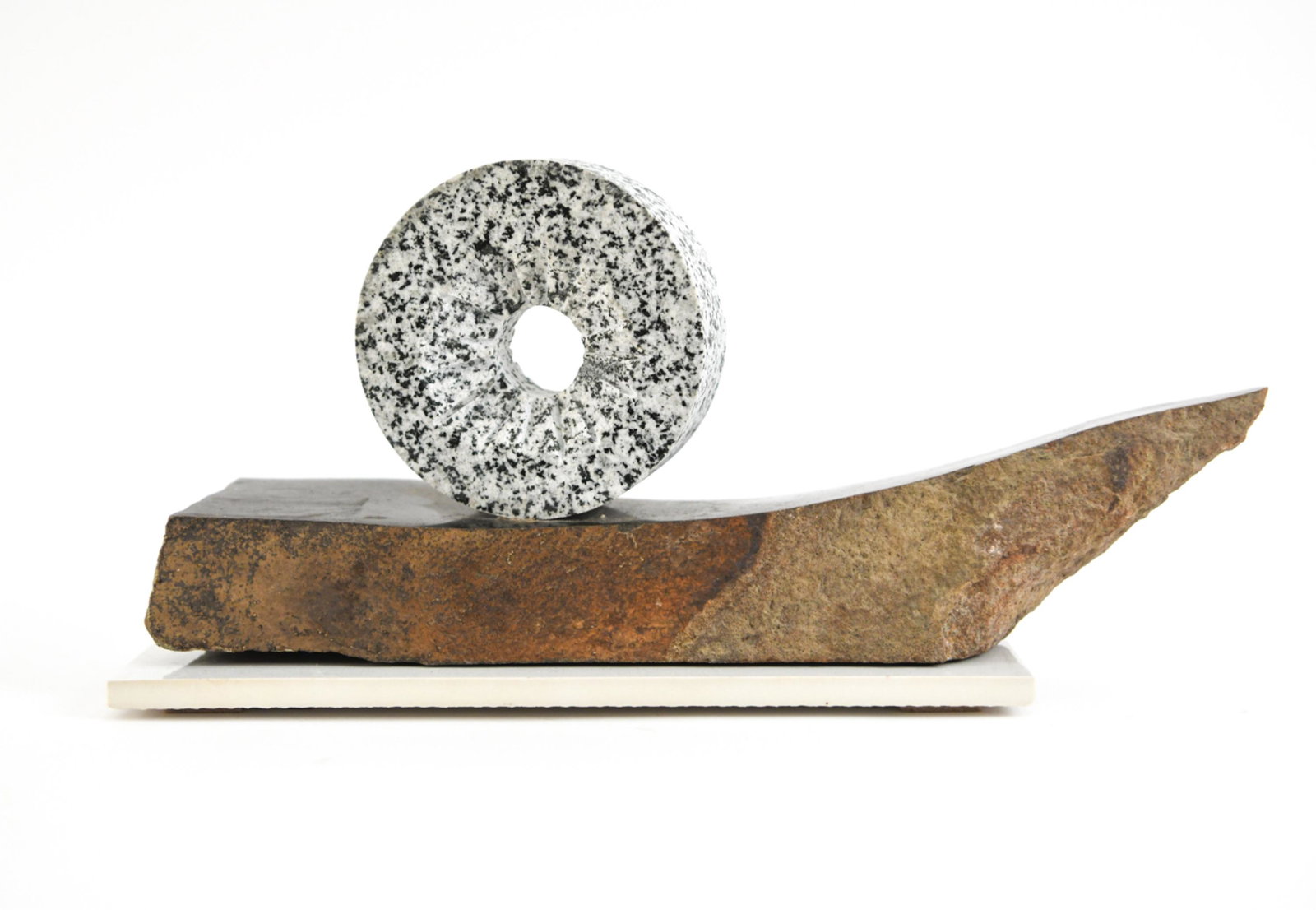 ABSTRACT CARVED STONE SCULPTURE: Apparently unsigned. Stone base with carved ring to top, possibly Dalmatian jasper stone. Dimensions: H 6.5" x W 15" x D 3.75" Condition: Few light surface scratches.