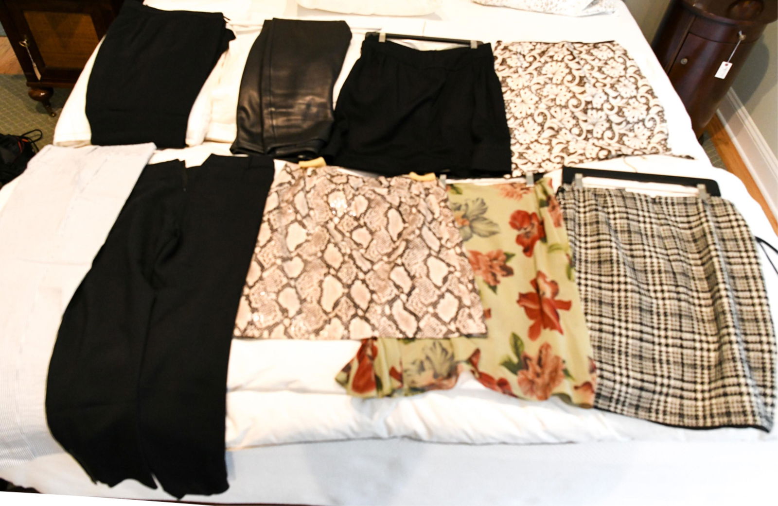 GROUPING OF LADIES DESIGNER SKIRTS AND PANTS: Including: DKNY black leather pants (size 8), Ann Taylor striped pants (size 6, new with tags), black pants (size 12), J. Crew black pants (size 4), Cynthia Steffe eyelet skirt (size 8), faux snakeski