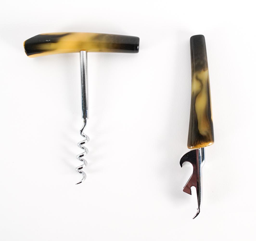 VINTAGE TRAV-L-BAR BAKELITE FAUX HORN BAR TOOLS: Circa 1970's corkscrew and bottle opener by Trav-L-Bar, featuring Bakelite faux-horn handles and chrome finish. Dimensions: (Bottle opener) L 6" x W 1" (Corkscrew) H 5" x W 3.75" Condition: Showing ve