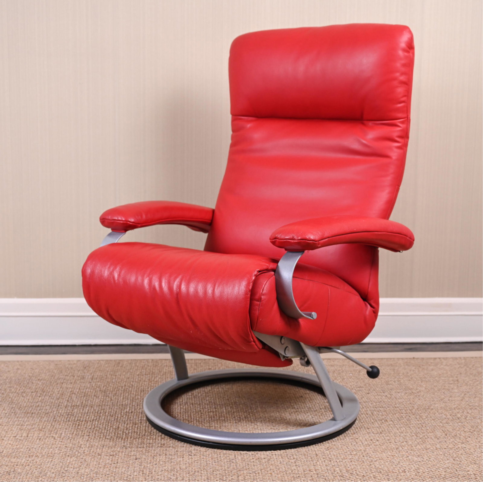 CONTEMPORARY RED RECLINING CHAIR: Bold red leather upholstery, metal base. With reclining footrest feature. Dimensions: (Not reclined) H 41.5" x W 28.25" x D 28.5" x SH 19.5" Condition: Few light marks and wear to upholstery. Minor sc