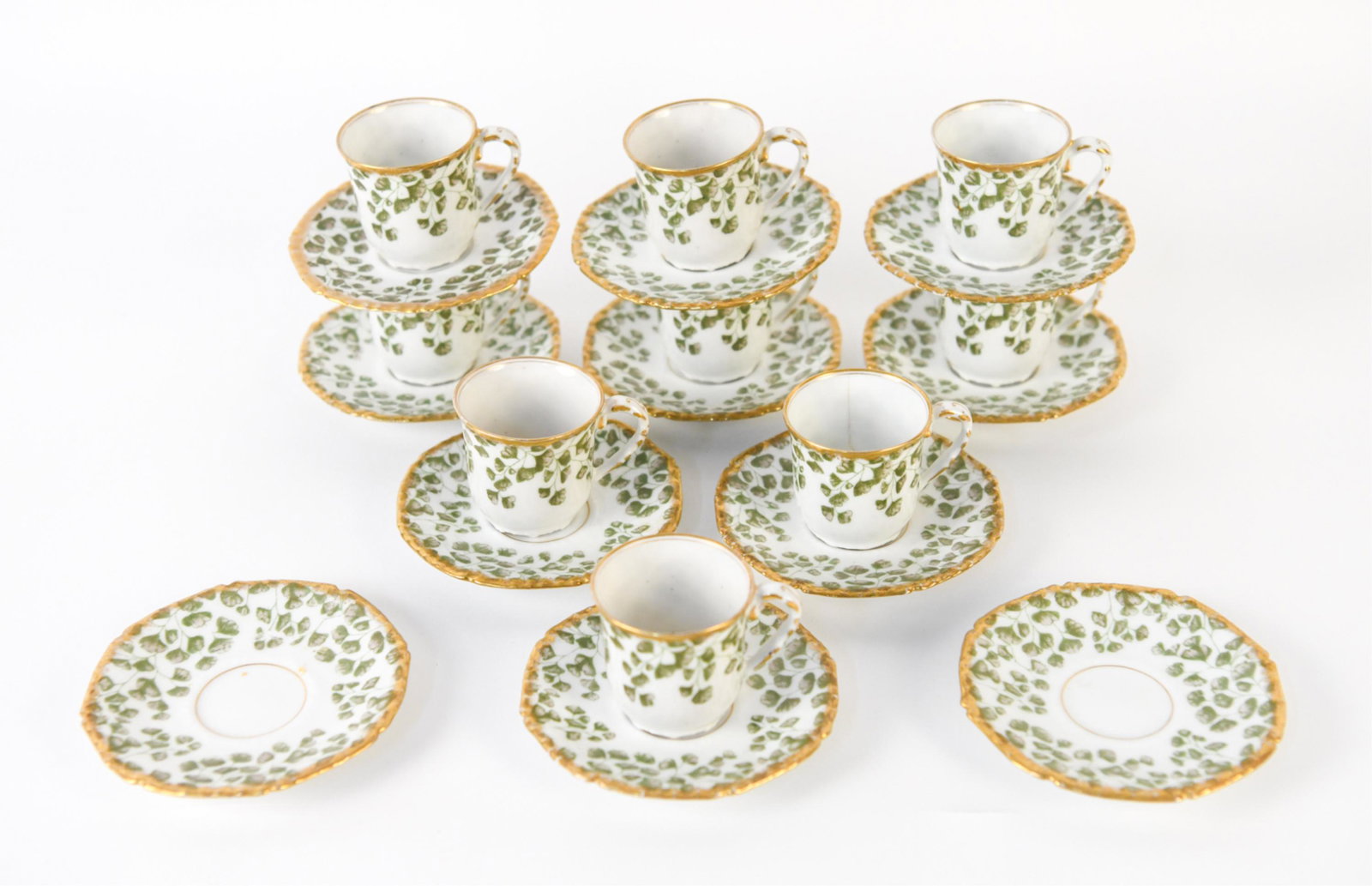 19TH C. LIMOGES PORCELAIN DEMITASSE SERVICE FOR 9: Beautiful antique demitasse set with delicate green clover-like motif and heavily gilt trim. Attributed to Tressemann & Vogt, with T&V mark and Ovington Bros. importer's mark underneath. Set includes: