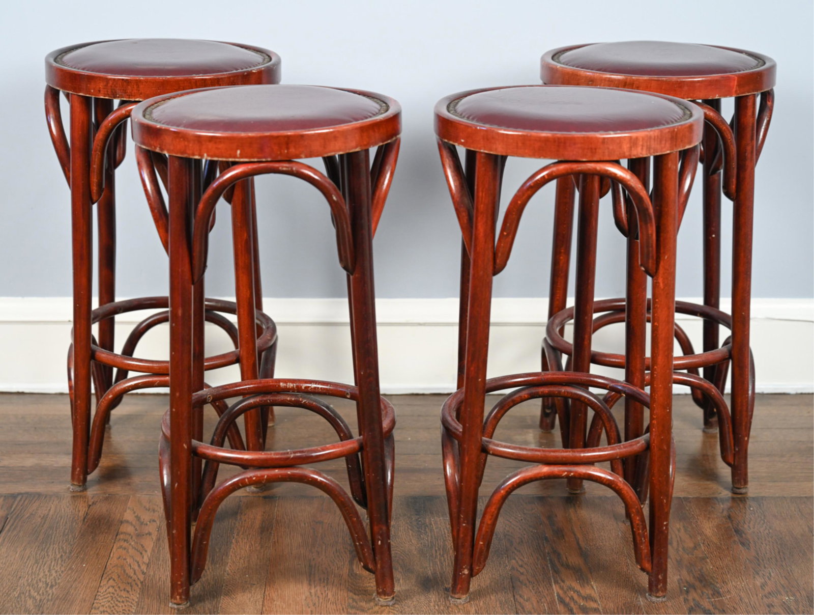 (4) BENTWOOD & TACKED LEATHER STOOLS: Dimensions: H 26" x Dia. 14.25" Condition: Some scuffs to stool legs and scratches to edge of seat.