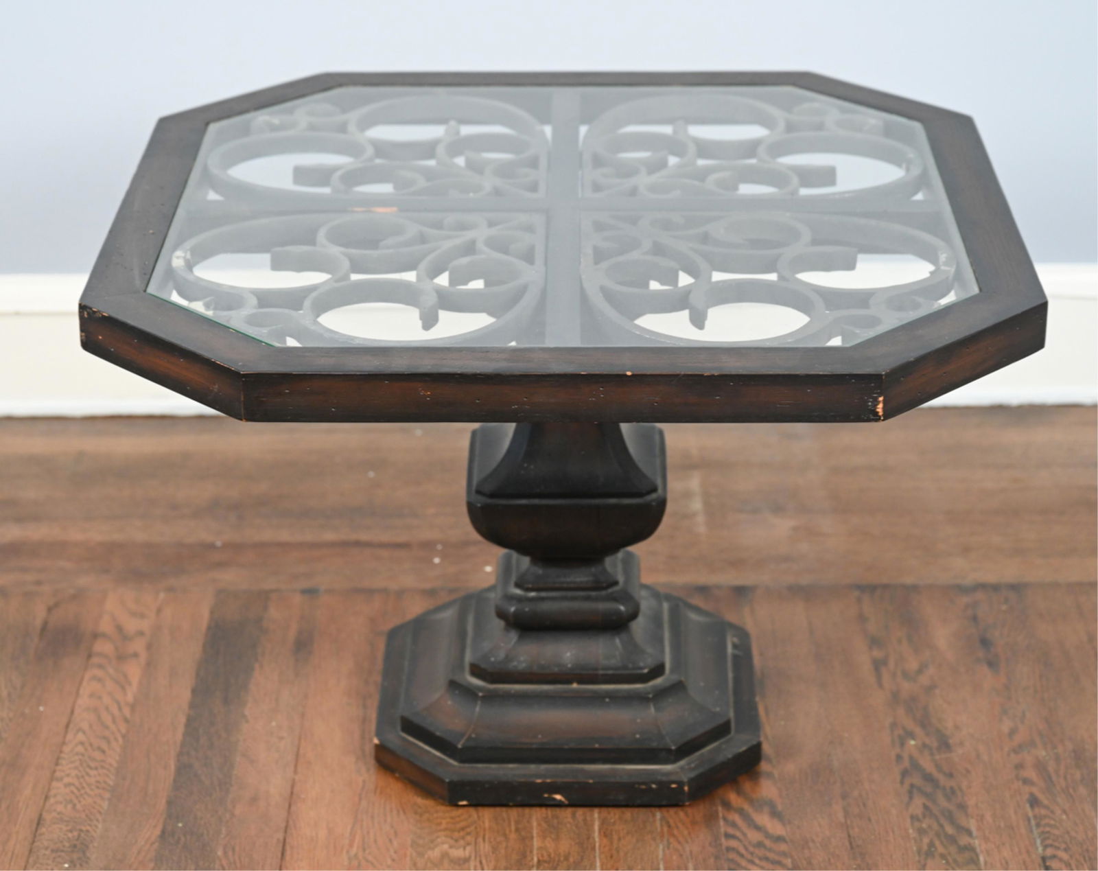 IRON AND WOOD COFFEE TABLE: Standing on one central pillar style leg. Dimensions: H 21" x W 32" x D 32" Condition: Scratches and scuffs. Iron with some losses to finish underneath glass.