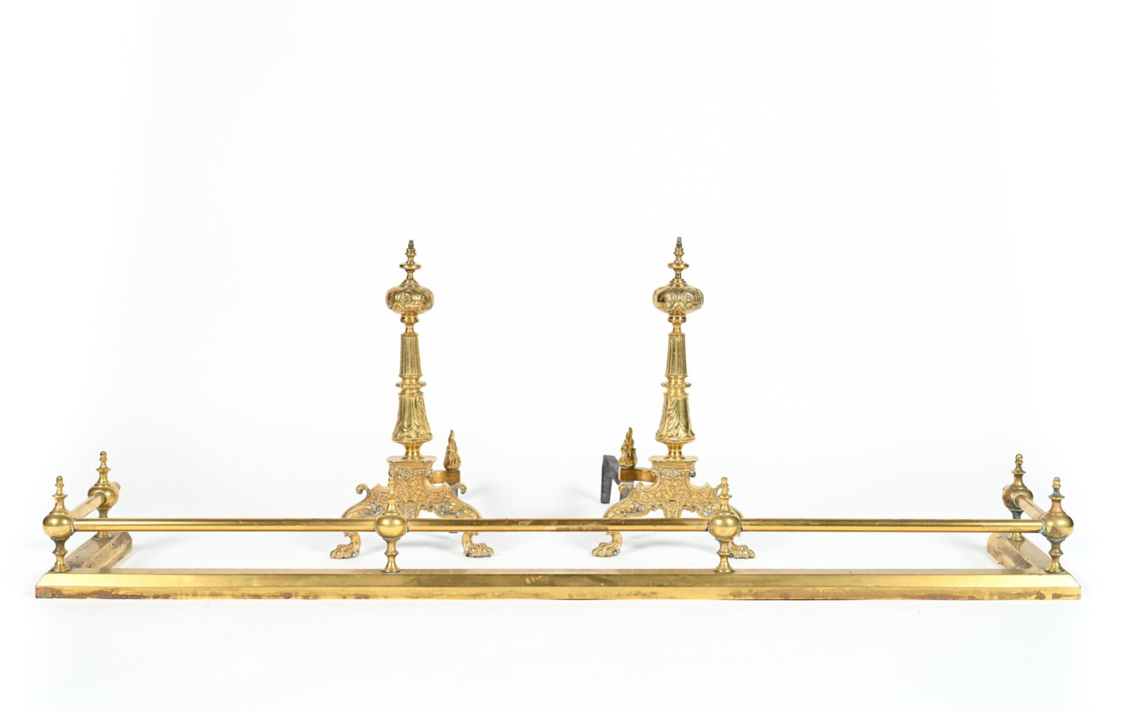 PAIR OF BRASS ANDIRONS & FIRE FENDER: Dimensions: (Fender) H 6.5" x W 57.5" x D 11.5" Condition: Showing normal signs of use including tarnish, oxidation.