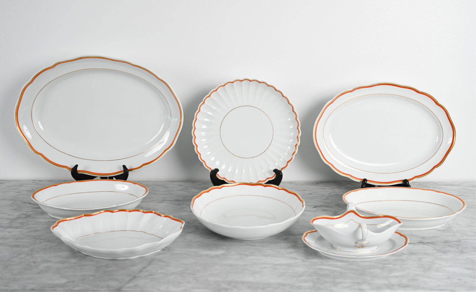 GROUPING OF MEISSEN PORCELAIN SERVEWARE: (8) Pieces, all marked, with red and gold banded trim. Dimensions: (Largest) H 2" x W 17" x D 12.5" Condition: Showing light wear consistent with age including minor knife marks and some rubbing to de