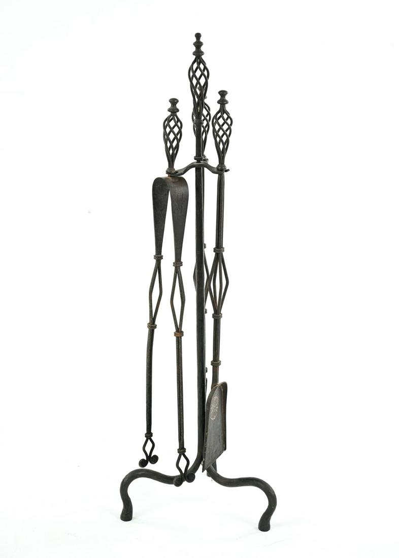 SAMUEL YELLIN STYLE FIREPLACE TOOLS: Iron fire tools in the manner of Samuel Yellin Dimensions: (Stand) H 39.5" x W 13" x D 13" Condition: Showing normal signs of us including some oxidation.