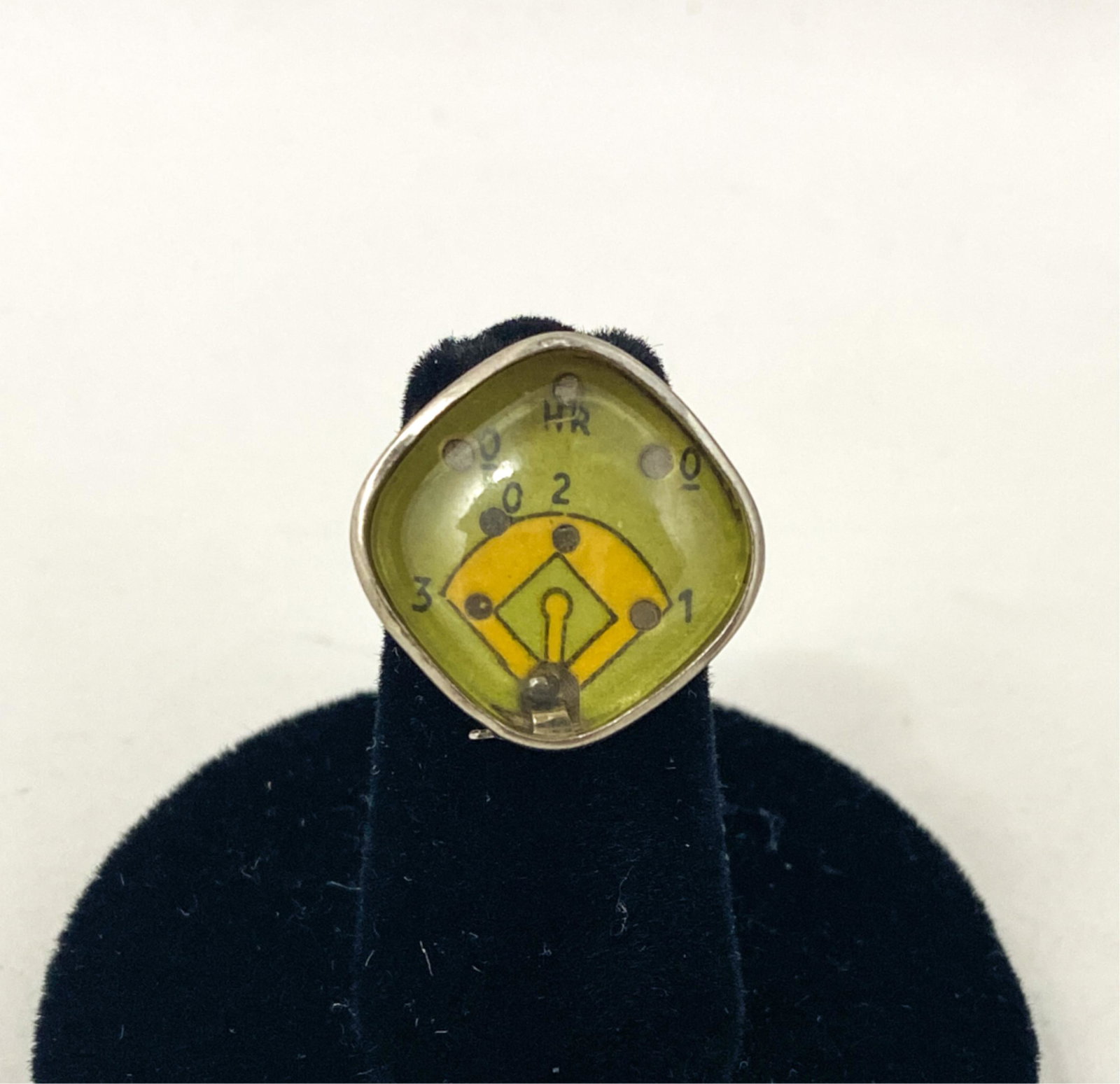 1949 KELLOGGS BASEBALL GAME RING: Ring has adjustable silvered metal base with a pair of raised baseballs and silvered metal top with diamond shaped clear plastic cover over a cardboard insert playing surface. The ring is designed lik