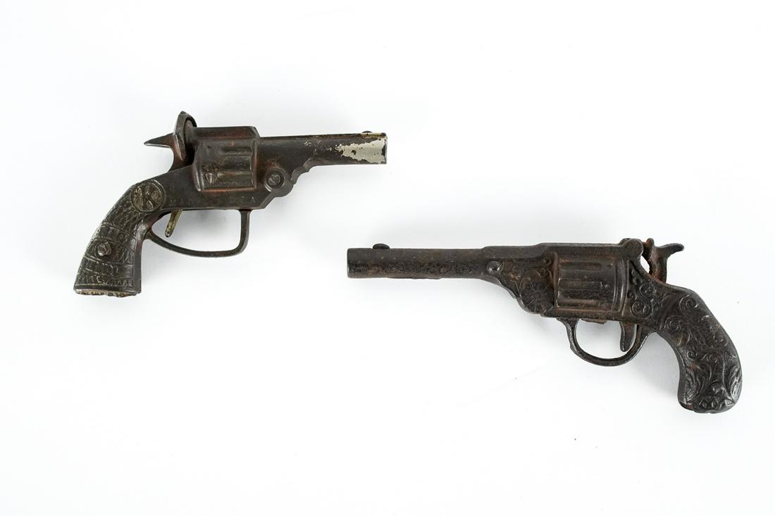 (2) ANTIQUE CAST IRON TOY PISTOL CAP GUNS: One marked Big Bill, the other patented 1890. Dimensions: (Larger) H 4" x L 7" x D 1" Condition: Not in working condition, rubbing and losses to finish, patina to metal.