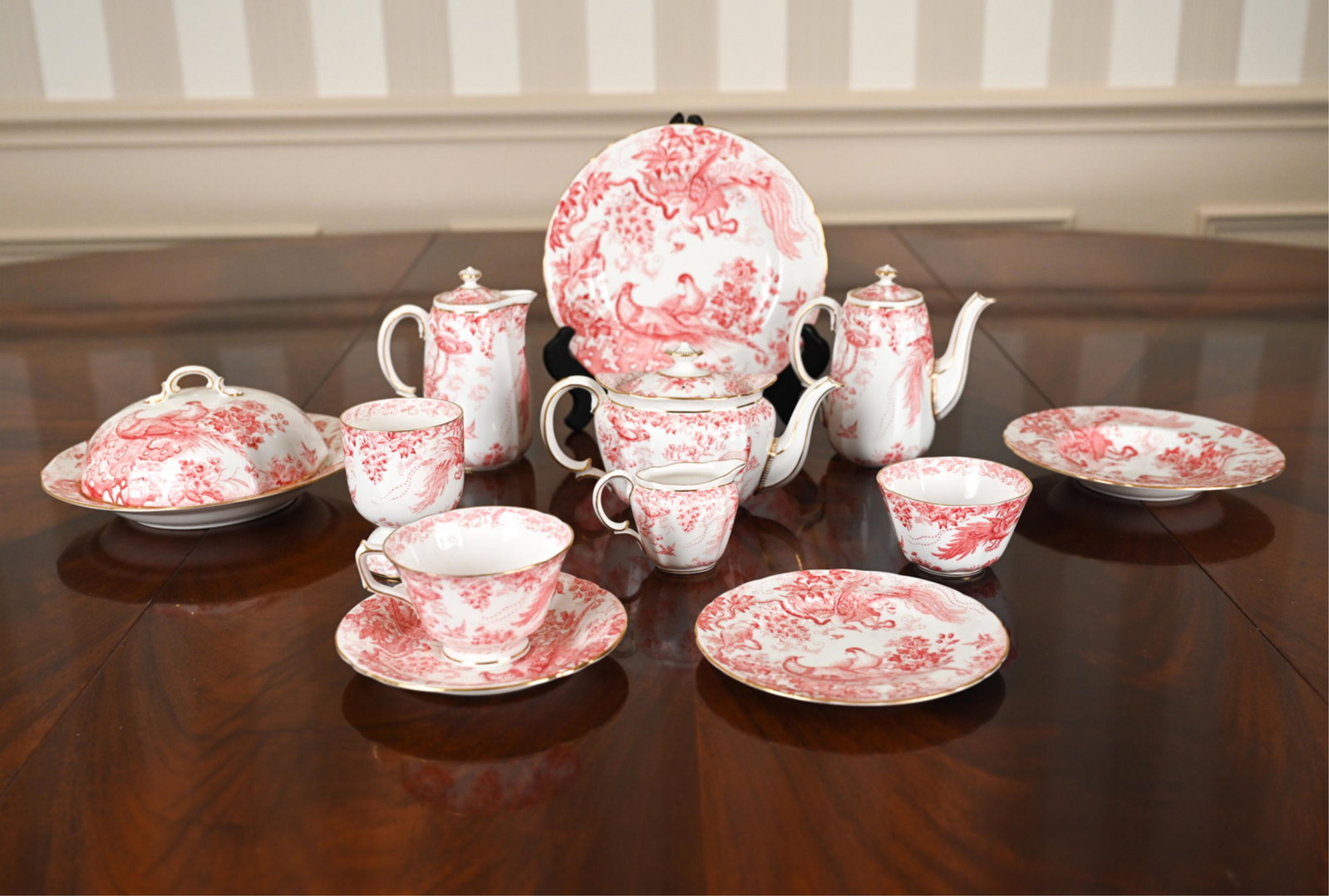 ROYAL CROWN DERBY BONE CHINA GROUPING: Raspberry transfer decoration with bird motifs. Including small single teapot, coffee pot, and chocolate pot, (2) teacups, (1) saucer, (3) plates of various sizes, (1) covered serving plate, (1) cream