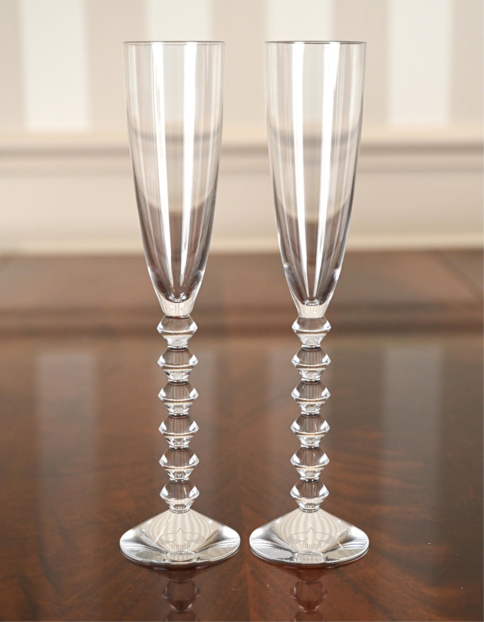 PAIR OF BACCARAT CRYSTAL VEGA TOASTING FLUTES: Both with etched marks underneath. Dimensions: H 11.5" x Dia. 2.75" Condition: No issues to note.