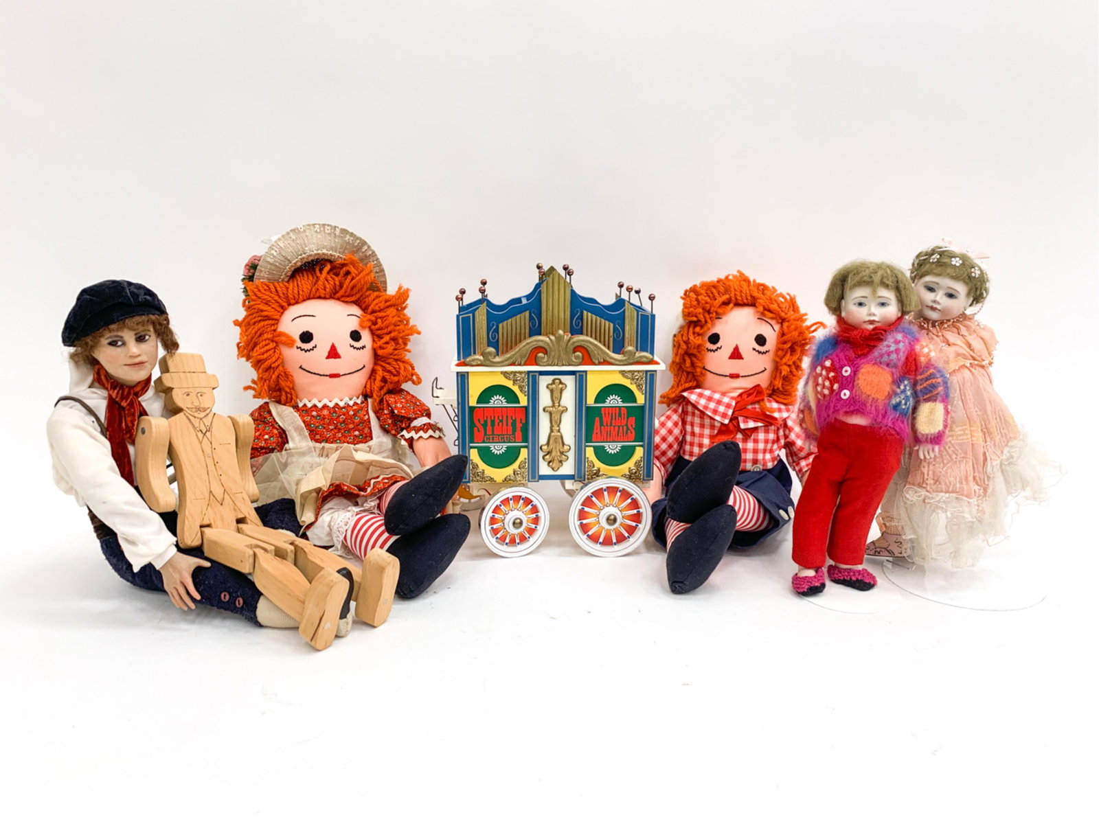 GROUPING OF DOLLS: Including Raggedy Ann & Andy and The Steiff Circus Carriage. Dimensions: (Largest) H 21" x W 8" x D 3" Condition: Showing some handling wear consistent with age. Few small possible losses. As shown.