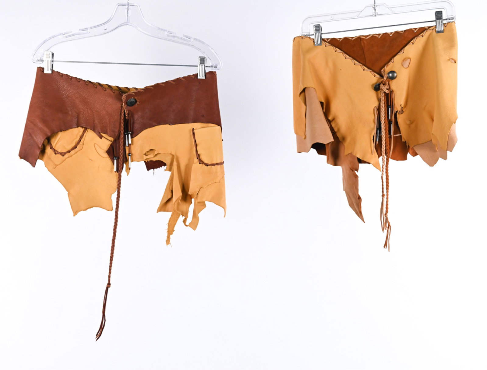 (2) VINTAGE LEATHER WHIPSTITCH SKIRTS: Waist size 30"-32". Condition: Showing various signs of wear consistent with age and use; raw hems with some additional tears, spots of soiling, a few nicks and small holes to leather. L170