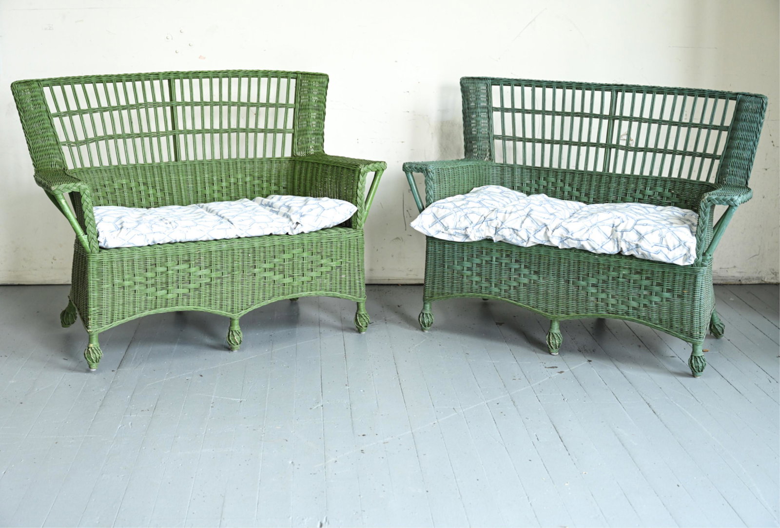 (2) VINTAGE PAINTED RATTAN & WICKER PATIO SETTEES: Painted slightly different shades of green. Dimensions: H 38" x W 51" x D 21" x SH 19" Condition: One frame slightly warped, with right feet lifting off ground. Otherwise showing normal wear consisten