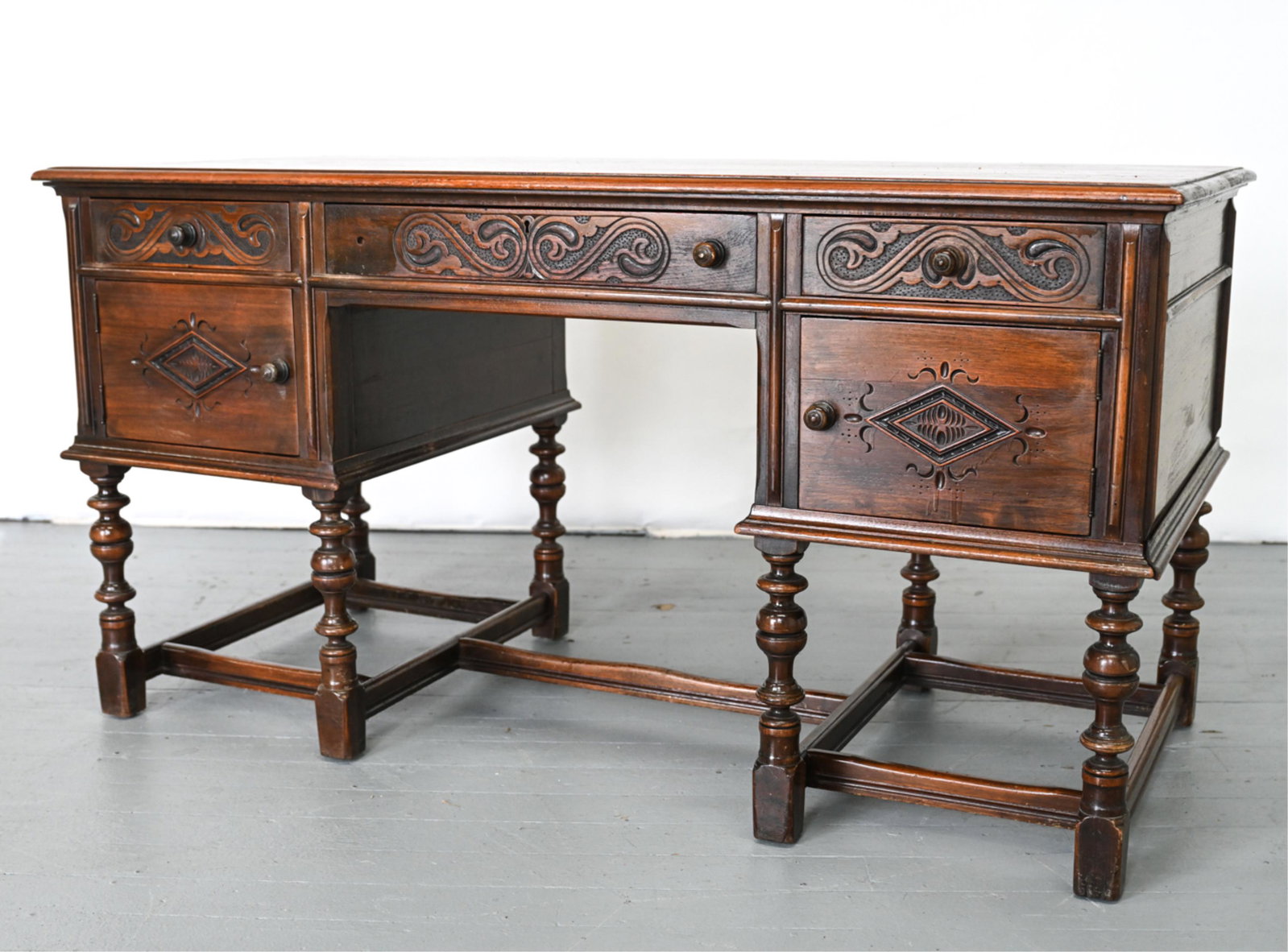VINTAGE WILLIAM & MARY-STYLE PARTNERS DESK: With dovetailed solid oak drawers, label remnants inside one drawer. 20th Century. Dimensions: H 30" x W 57" x D 27.25" Condition: Missing key. Desk sturdy. Some very minor joint separation, scattered