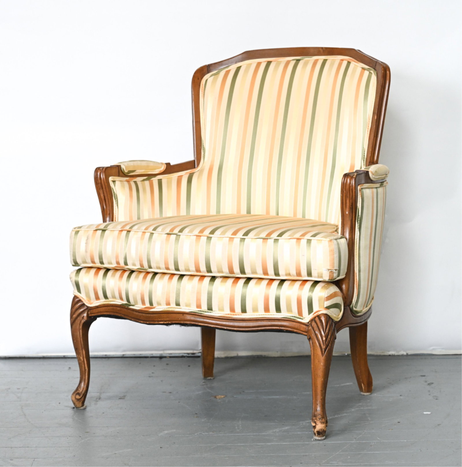 VINTAGE FRENCH BERGERE CHAIR: Multi-color stripe silk upholstery. Dimensions: H 35" x W 28.5" x D 28.5", SH: 19" Condition: Chair appears to have been reupholstered. There are multiple areas that show fabric snags as well as areas