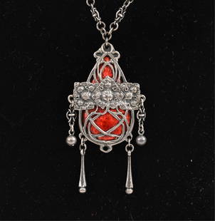 RAMSDEN & CARR -SILVER AND ENAMEL PENDANT: Hallmarked, London 1905, maker Omar Ramsden & Alwyn Charles Ellison Carr, the fringed ovoid drop overlaid with three stylized leaves and scrolls to a red enameled ground suspended from a fancy link ch