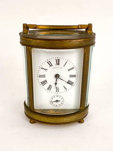 ANTIQUE TIFFANY & CO CARRIAGE CLOCK: Tiffany & Co. oval brass carriage clock with beveled glass. Marked made in France, signed and numbered to back of movement. Dimensions: H 4.25" x W 3" x D 2.25" Condition: Rich patina and surface